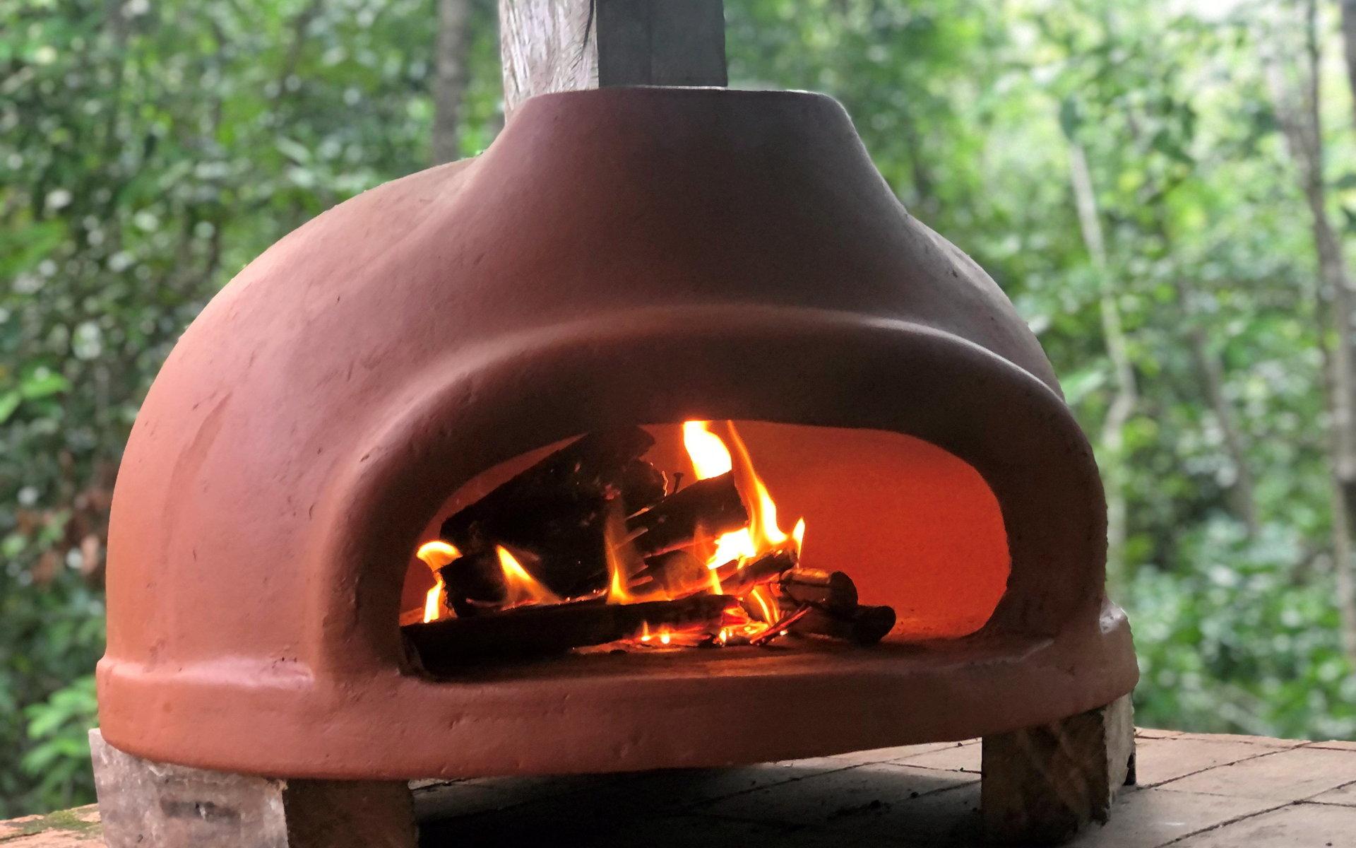 Vedugnen är handgjord i Mexiko. ”Man lägger in ved och eldar, som i en traditionell pizzaugn. Vi lagar allt möjligt där: pizza, lax, potatisgratäng, med mera. Det blir en fantastisk smak.” 