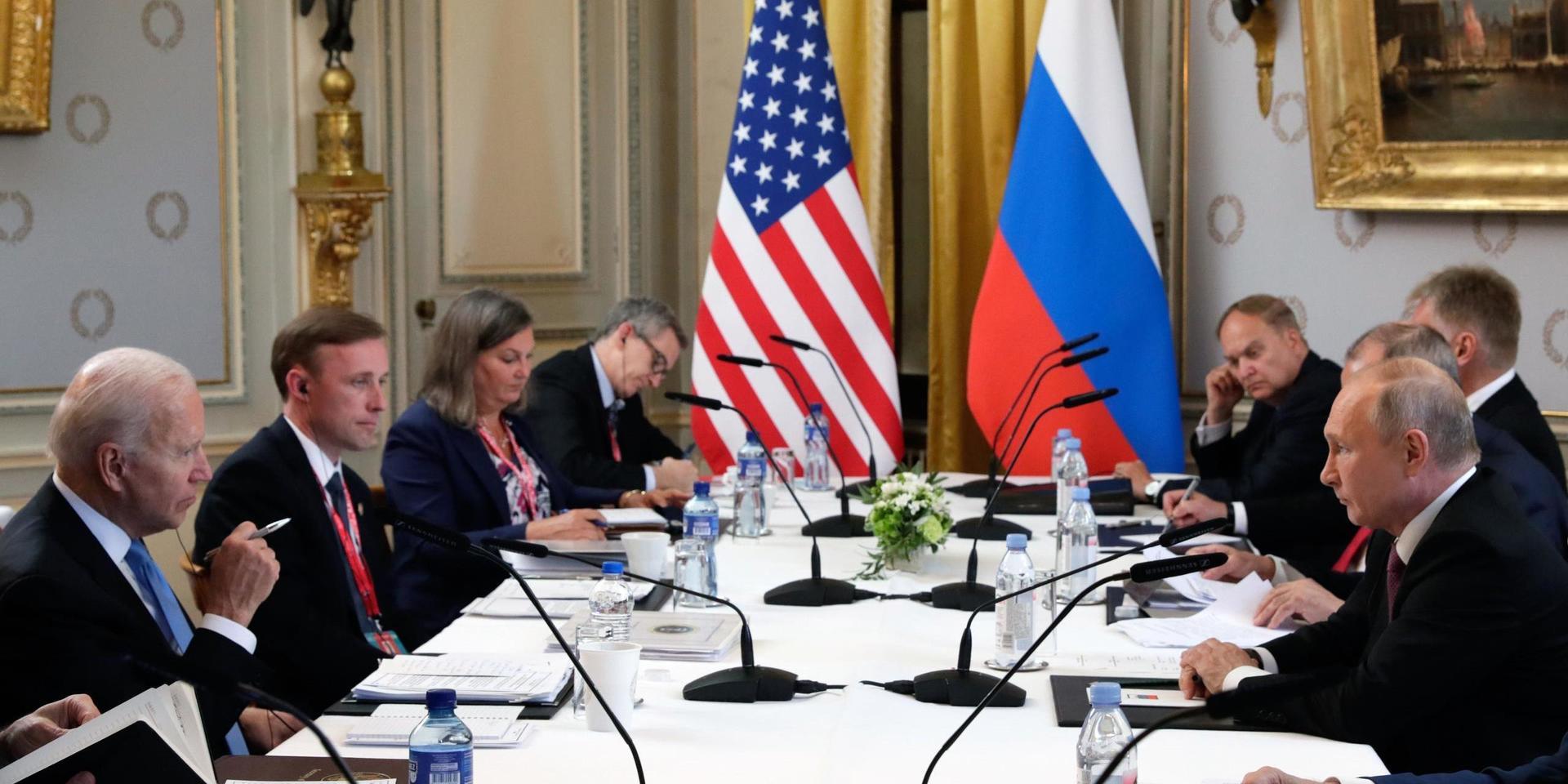 USA:s president Joe Biden med delegation på vänstersidan av bordet, ryske presidenten Vladimir Putin med medhjälpare till höger.