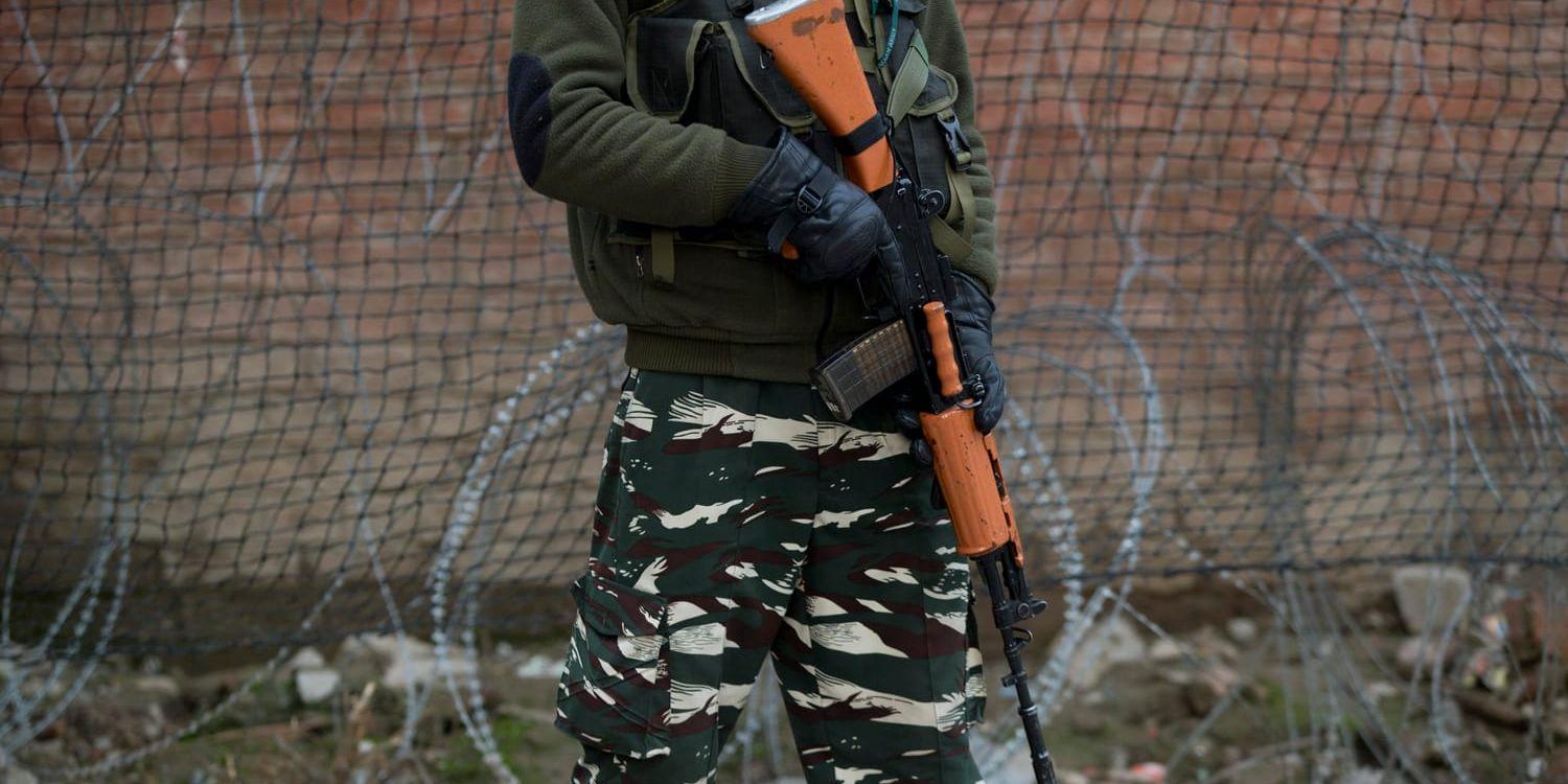 En indisk paramilitär soldat står vakt utanför basen i Srinagar, i den Indienkontrollerade delen av Kashmir. Arkivbild.