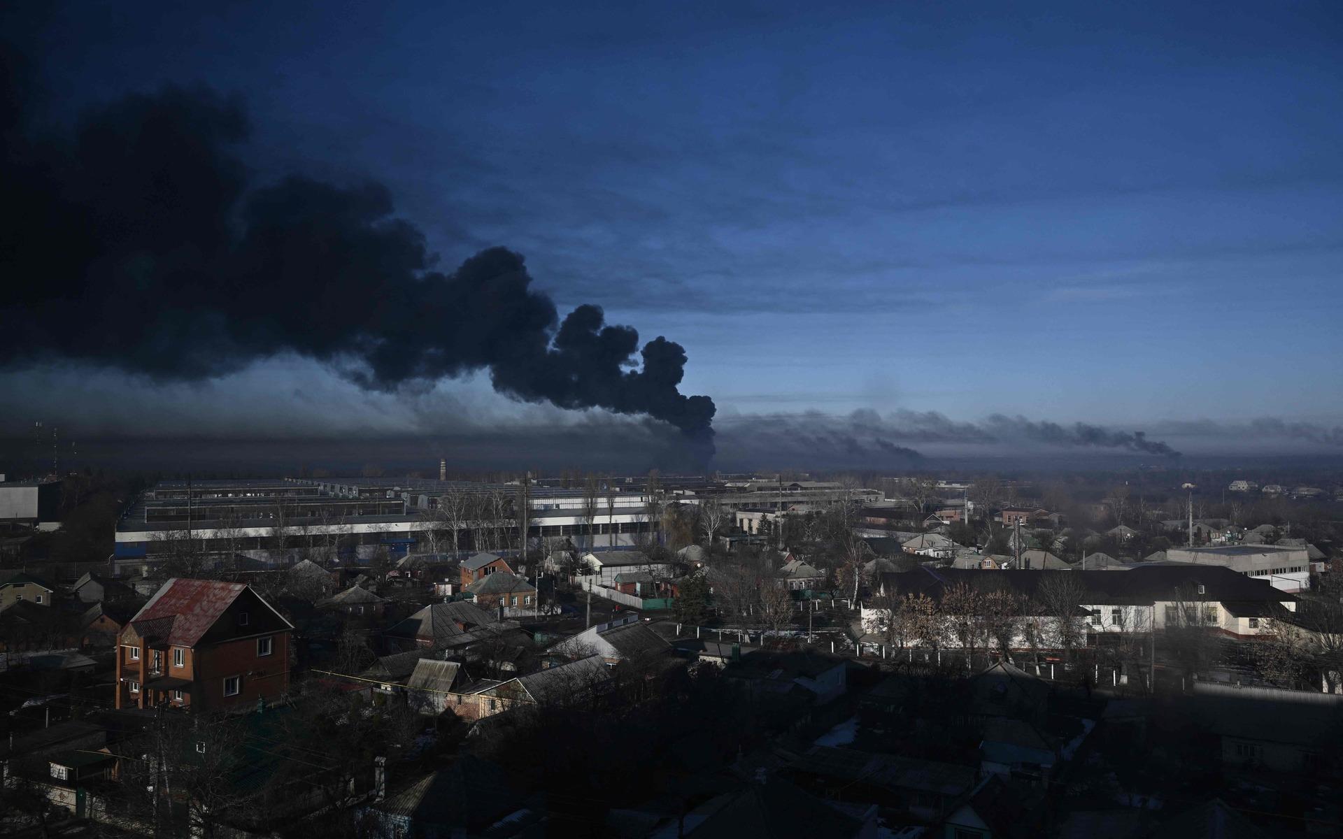 Svart rök stiger från en militärflygplats i staden Tjuhujiv, som ligger strax utanför miljonstaden Charkiv i östra Ukraina på torsdagsmorgonen.
