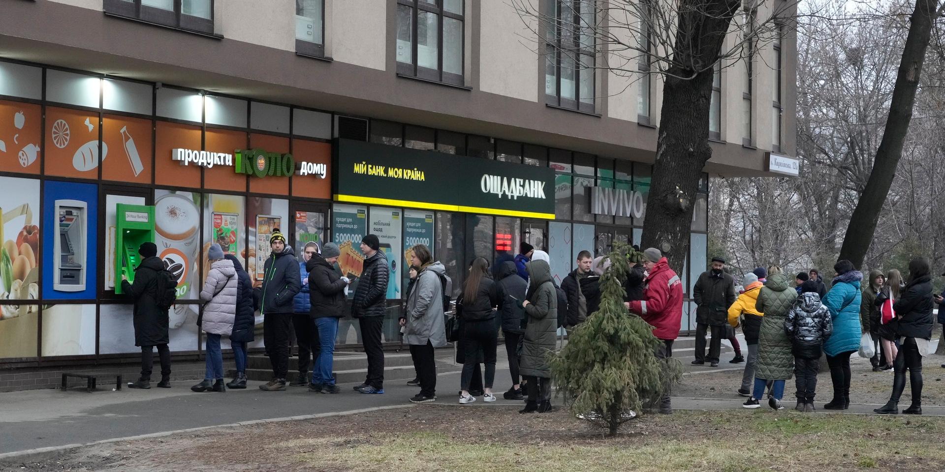 Människor köar för att ta ut pengar vid en bakomat i Kiev under torsdagsförmiddagen.
