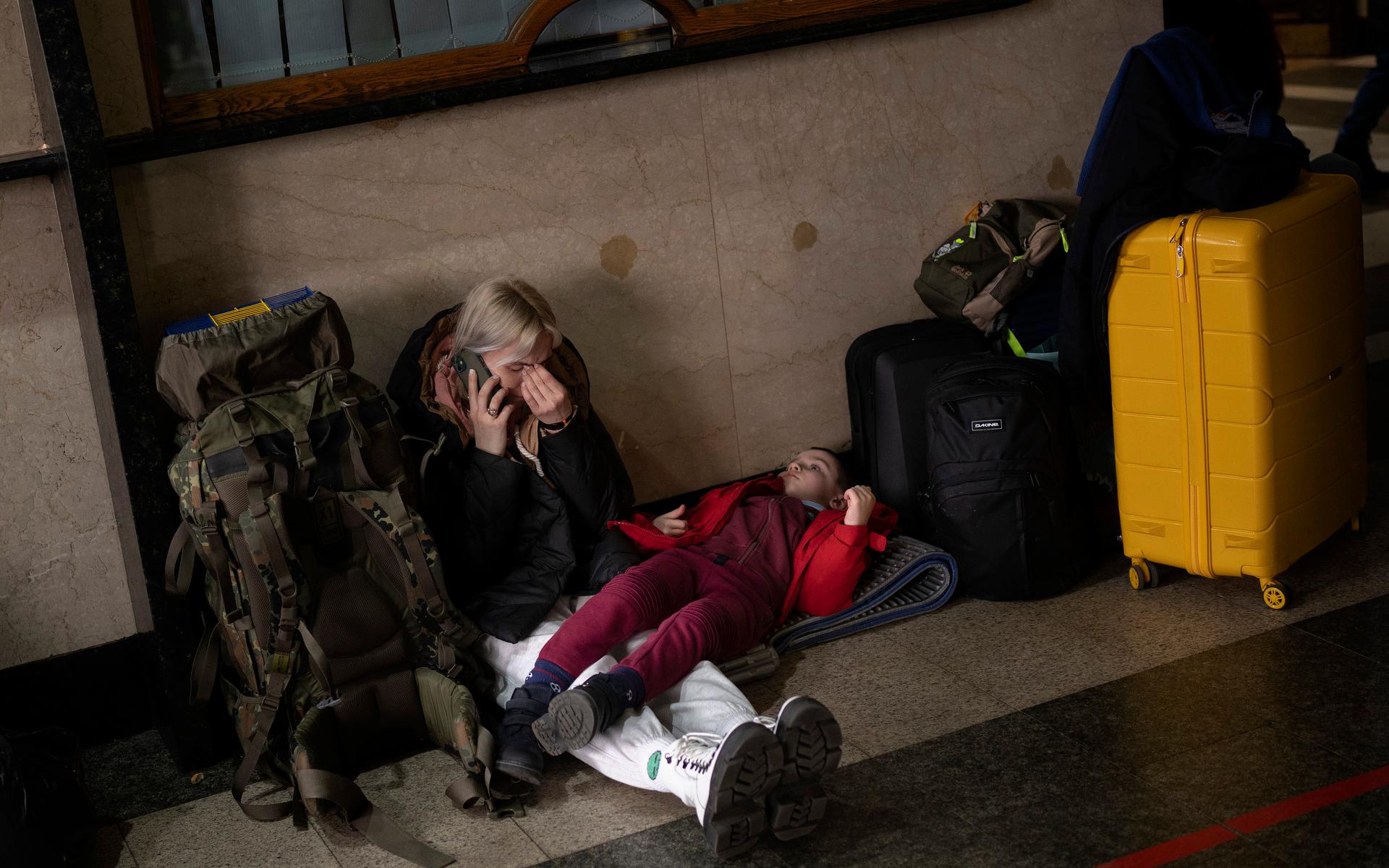 En kvinna med sin dotter väntar på ett tåg för att lämna Kiev efter att Ryssland anfallit staden med missilattacker under natten.