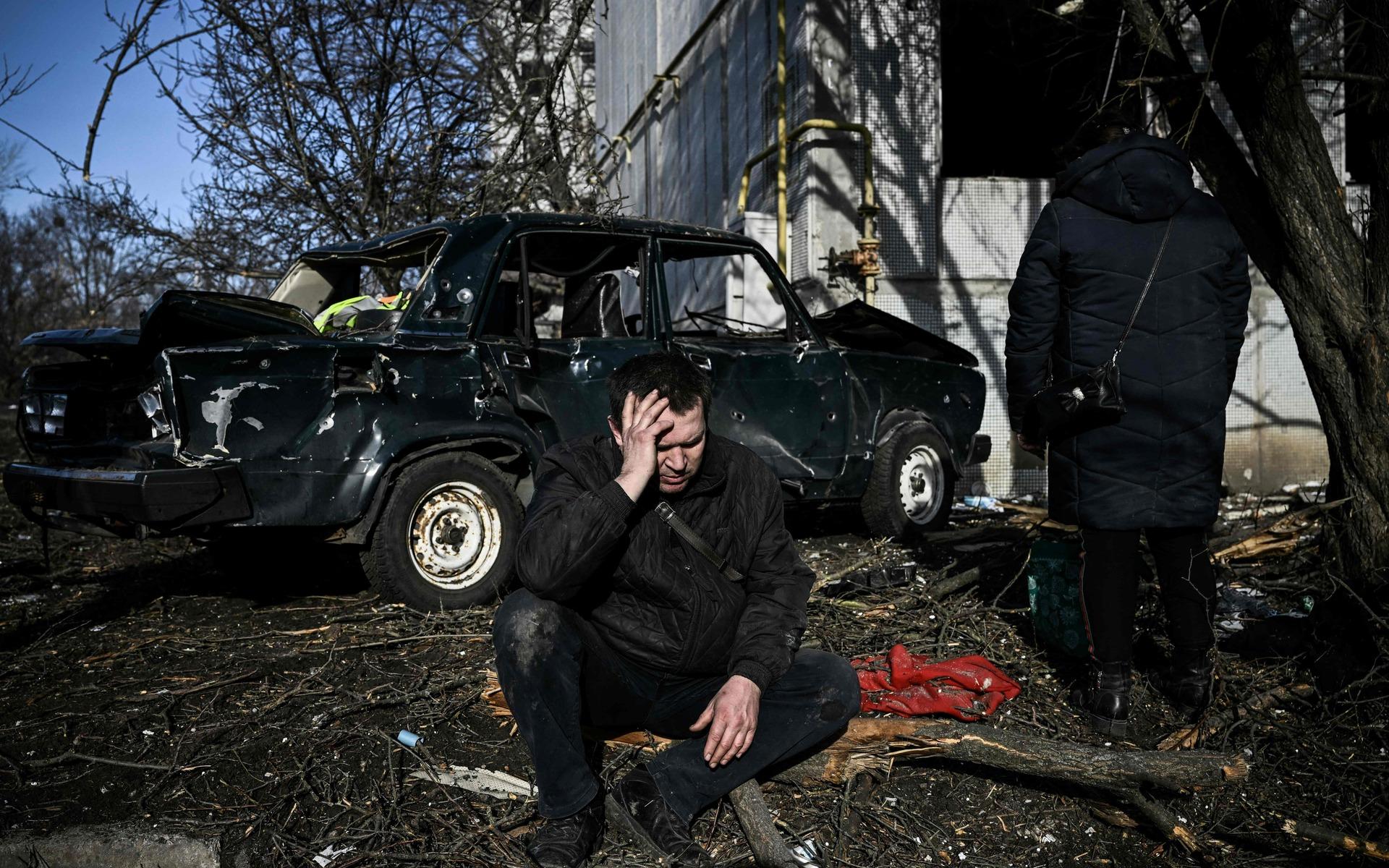 En man utanför ett förstört hus i Tjuhuiv i östra Ukraina. 