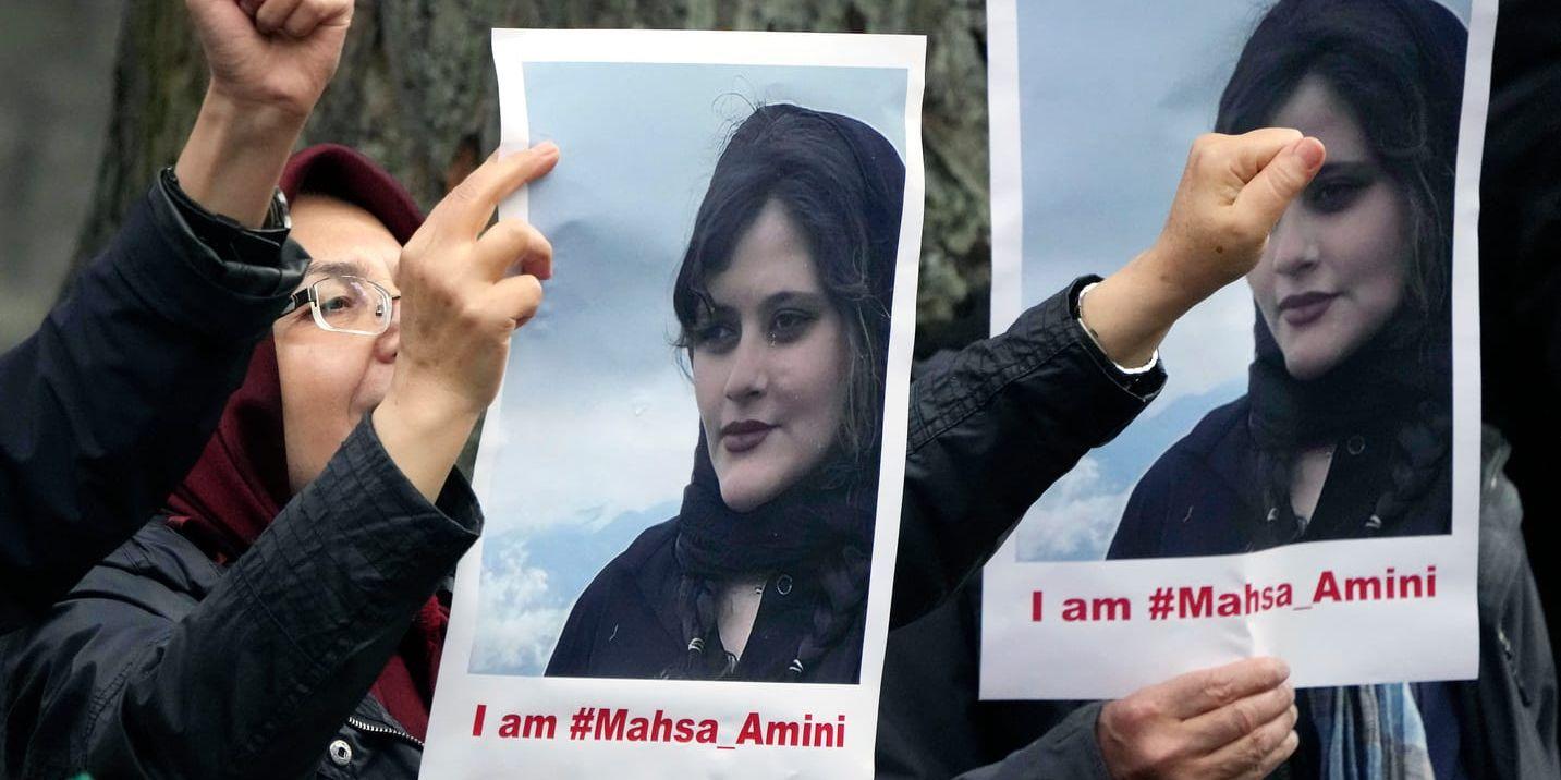 Iranska kvinnor samlade utanför den iranska ambassaden i Berlin i tisdags. På bilden syns 22-åringen som dog i den iranska moralpolisens häkte.