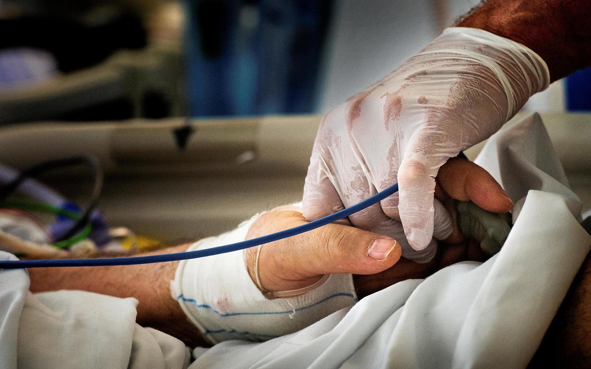 Mats Johag håller patientens hand.