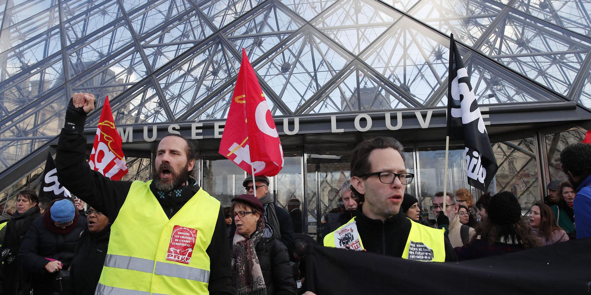 Strejkande aktivister blockerar ingångarna till Louvren i Paris. 