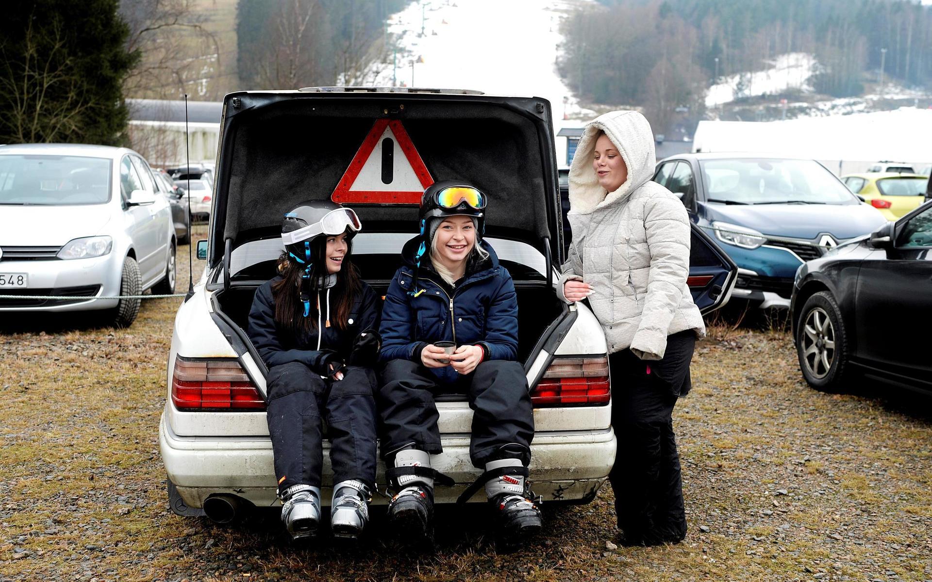 Vännerna Annie Bengtsson, Ellen Göransson och Cassandra Nilsson som tar sig en välförtjänt fikapaus i bagageluckan av deras Volvo.