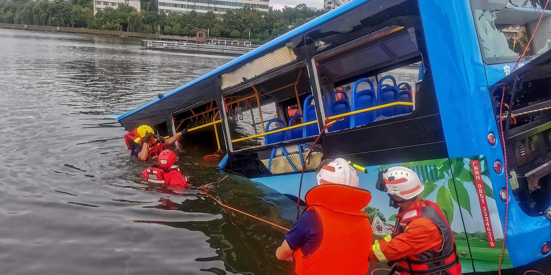 Räddningsarbetare bärgar bussen från sjön i kinesiska Anshun.