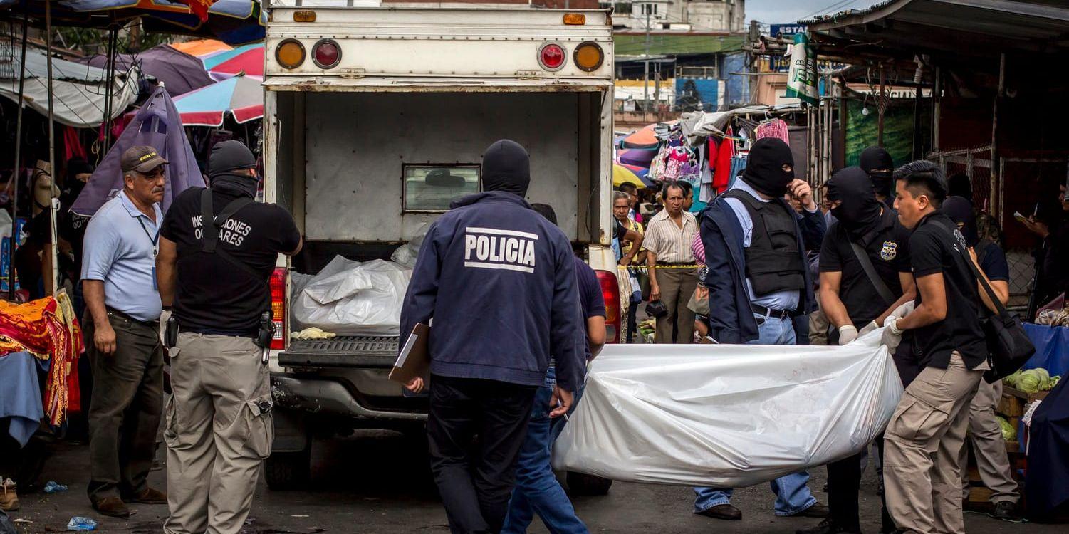 Poliser bär undan dödsoffer för gängkriminalitet i El Salvadors huvudstad San Salvador. Arkivbild.