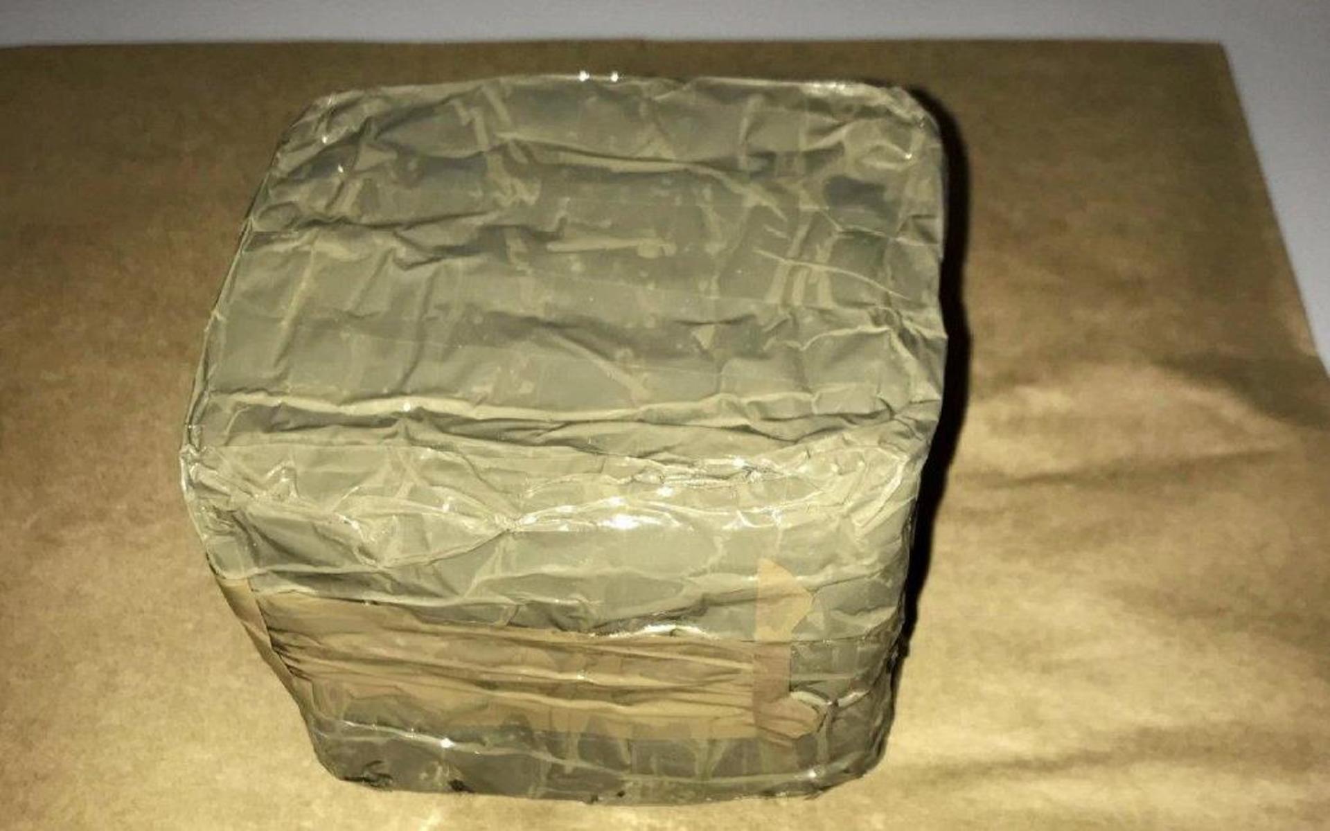 En ung man från en Stockholmsförort greps efter att ha köpt ett kilo hasch. Han försökte gömma den fyrkantiga förpackningen i ärmen på en jacka. 