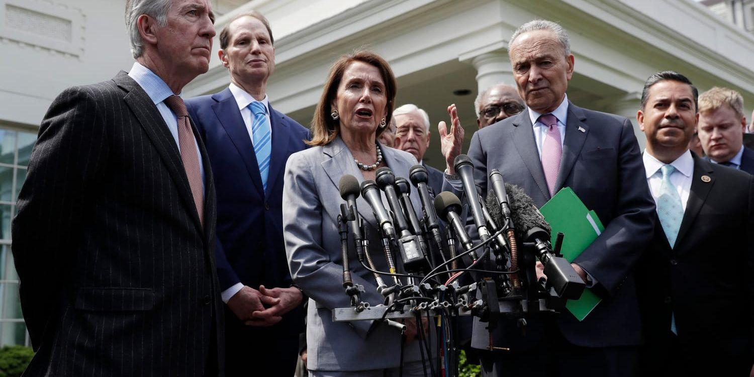 Demokraternas kongressledare Nancy Pelosi och Chuck Schumer, omgivna av partikamrater, uttalar sig för medierna efter tisdagens möte med president Donald Trump i Vita huset.
