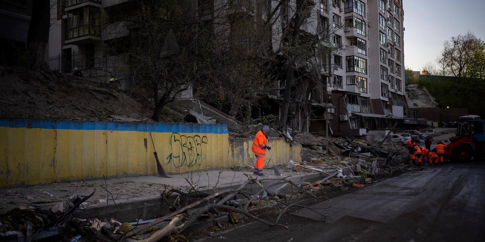Kämpar. Städpersonal rensar upp efter ett flyganfall i Kiev.