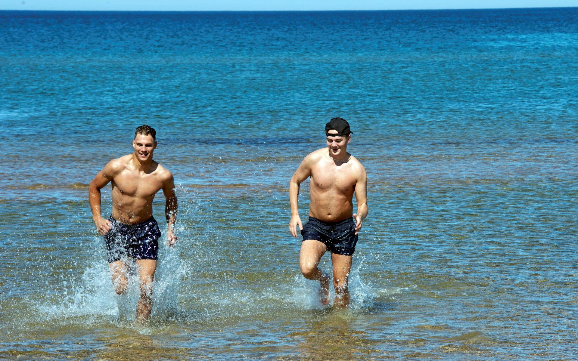 Kompisarna Alexander Jansson och Max Georgson håller sig varma i vattnet genom att vara aktiva och hela tiden röra på sig.