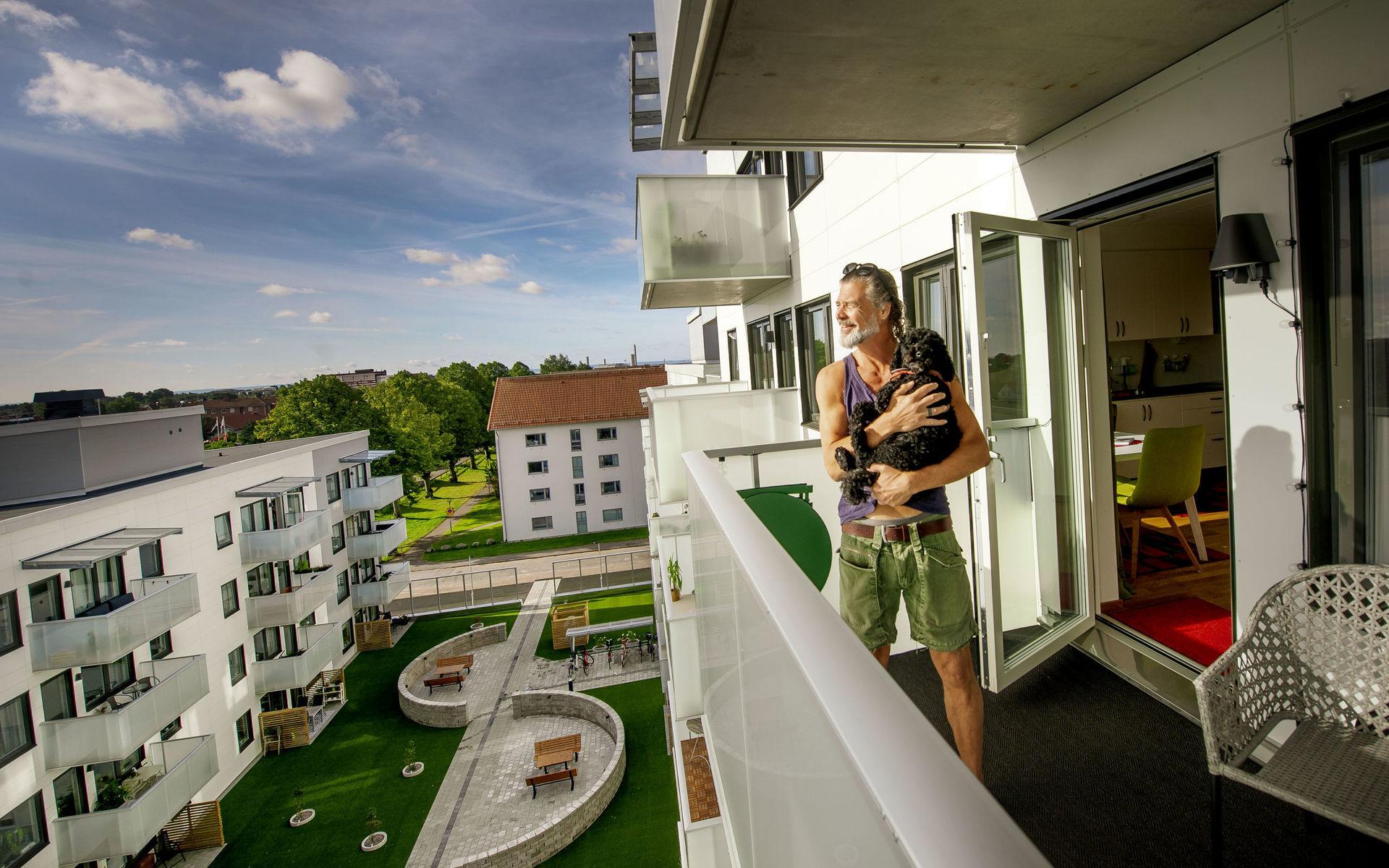 Fredrik Panzio och hunden Svea trivs på sjätte våningen i det nybyggda hyreshuset på Bolmensgatan. Från balkongen har de utsikt mot innergården och takåsarna på Öster. I bakgrunden syns Fredriks arbetsplats Högskolan. 