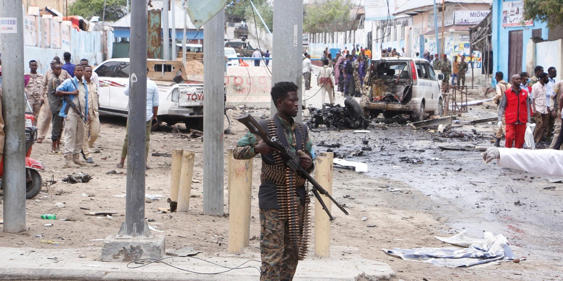 En somalisk soldat framför platsen där en självmordsbombare slog till i huvudstaden Mogadishu på lördagen. Minst åtta människor miste livet i attacken.