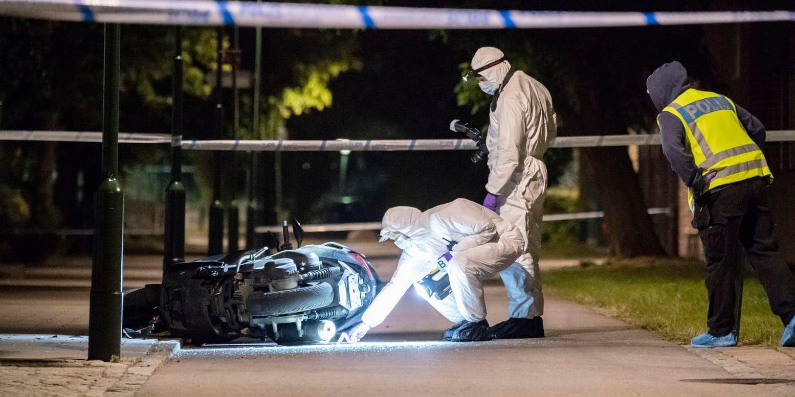 Polisens kriminaltekniker undersöker en moped på en gångbana vid Lindängsplan i Malmö efter det att en man skjutits.