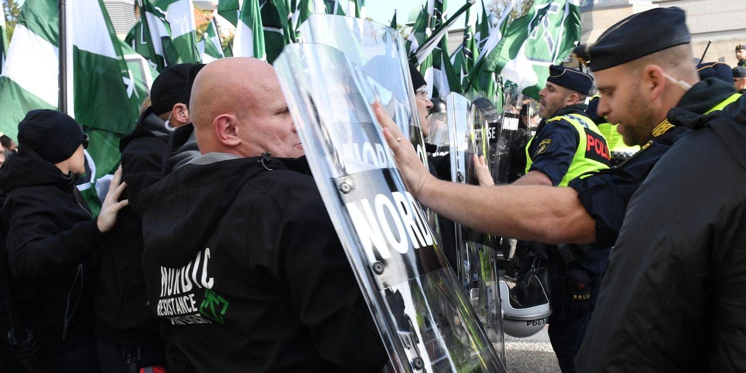 Medlemmar i Nordiska motståndsrörelsen (NMR) hejdas av polis under demonstrationen på lördagen.