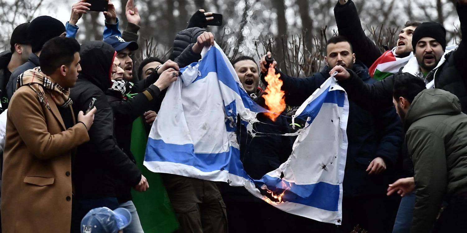 Demonstranter tänder eld på en israelisk flagga. Palestinagrupperna höll demonstration i Humlegården i Stockholm mot USA:s beslut att flytta sin ambassad till Jerusalem.