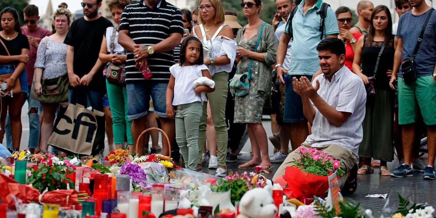 En man ber vid ett minnesmärke för offren för skåpbilsattacken på gatan Las Ramblas i Barcelona.