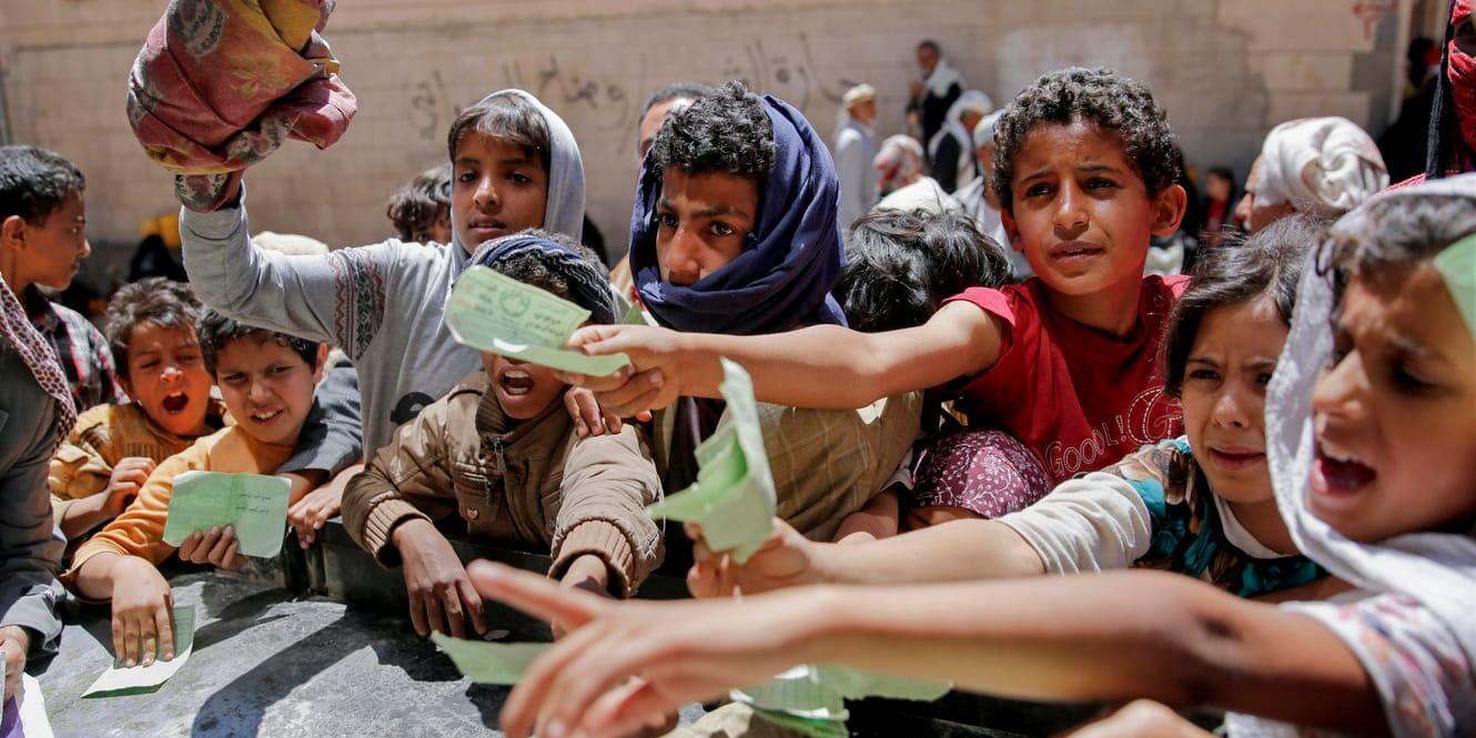 Barnen i Jemen får det allt svårare visar en ny rapport från Unicef. På bilden syns pojkar och flickor som visar som visar upp handlingar för att få matransoneringar i staden Sanaa. Arkivbild.