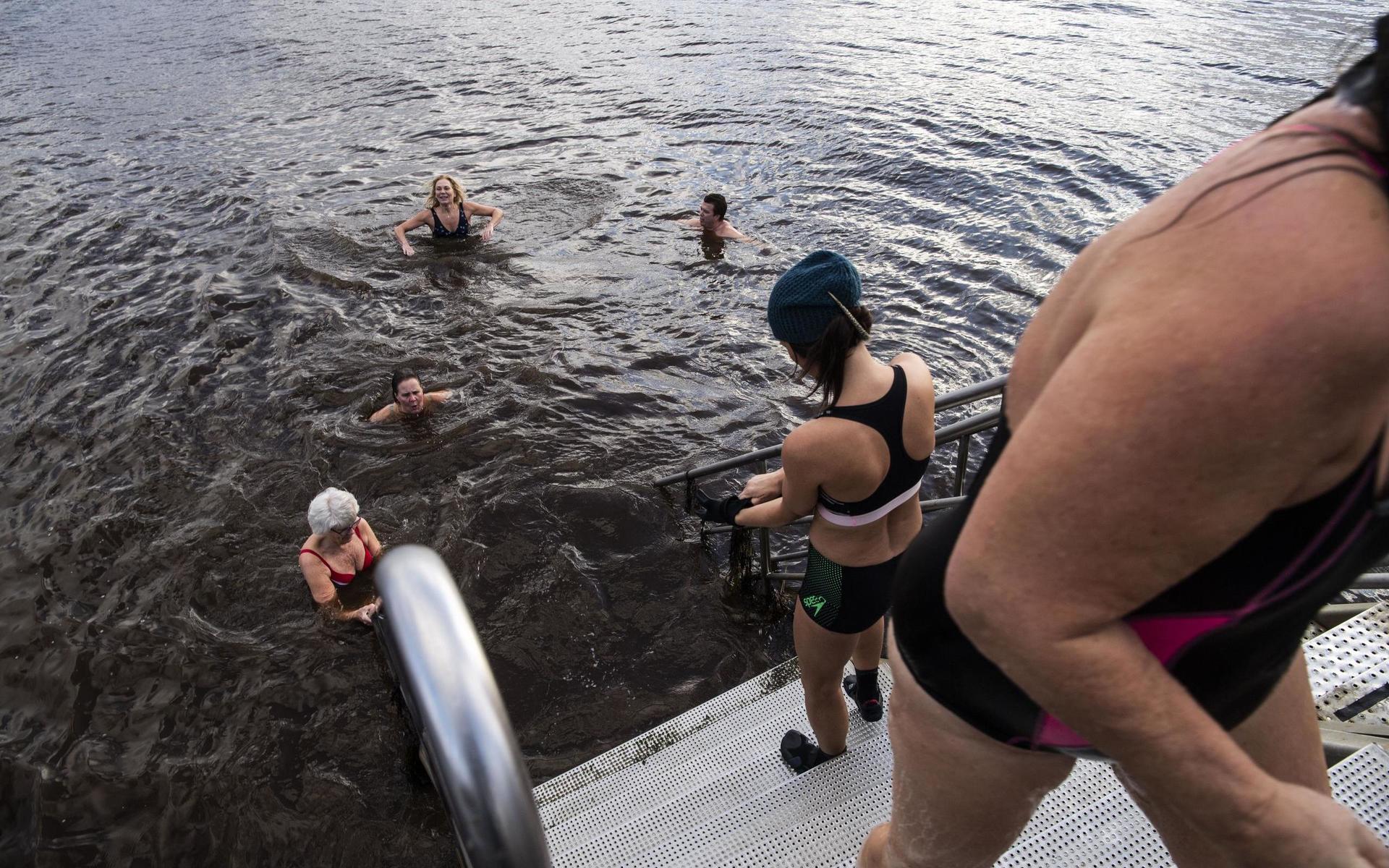Facebookgruppen gör det lätt att hitta badkompisar och det rekommenderas inte att man går i det kalla vattnet ensam. Här är det Carina Haggren som gör sig redo för ett dopp, medan Marie Bengtsson badat färdigt för den här gången.