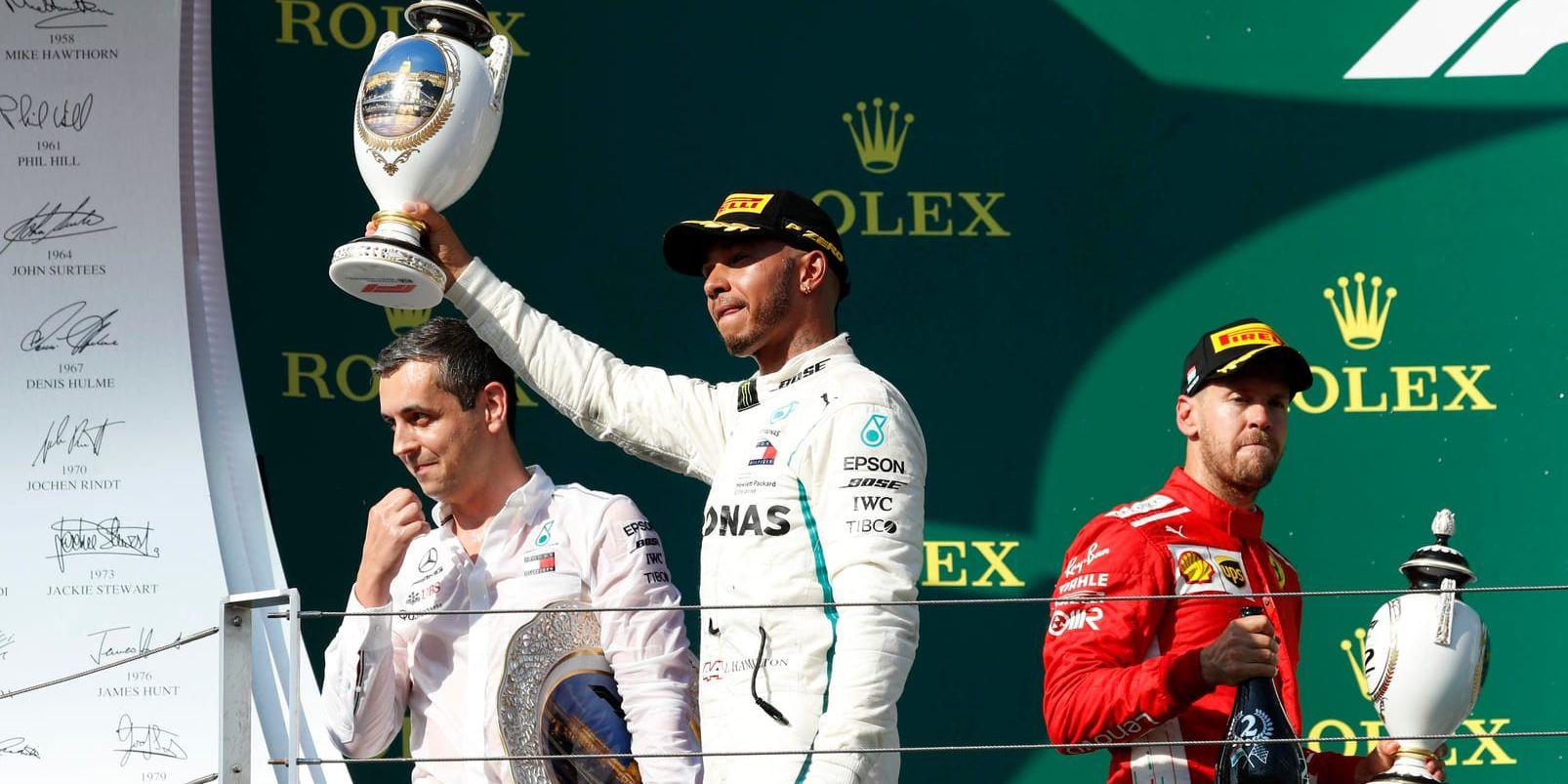 Lewis Hamilton höjer segerpokalen efter segern i Ungerns GP. Tvåan Sebastian Vettel ses till höger.