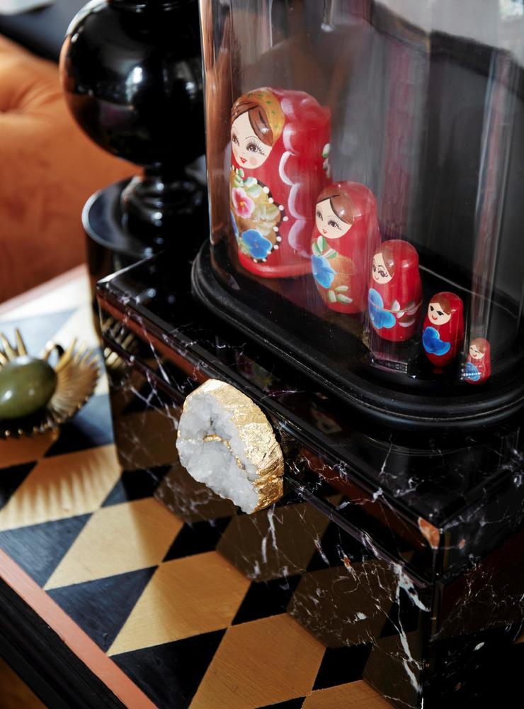 Ett gammalt sidobord har målats med harlequinrutor, något av Tanyas specialitet. Glaskupa från Magasin 7 som rymmer ryska dockor, köpta second hand.