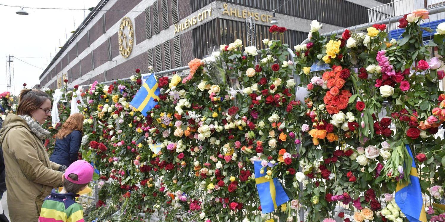 Människor besöker avspärrningarna vid Åhléns City i centrala Stockholm dagen efter terrordådet på Drottninggatan i april i fjol. Arkivbild.