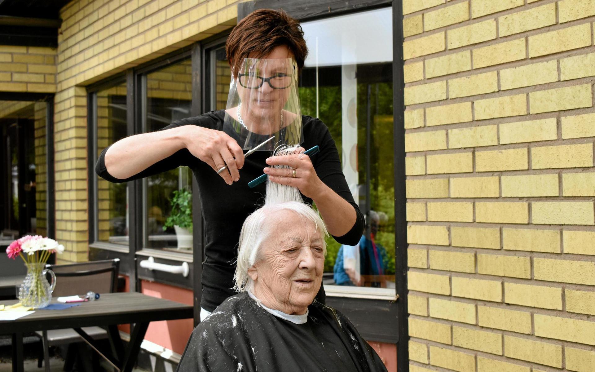 9 juni. När det rådde besöksförbud på kommunens äldreboenden tog frisören Marie Nyberg på sig visiret och klippte de gamla utomhus. 102-åriga Helga Ahlqvist var en av dem som fick ny frisyr i somras.