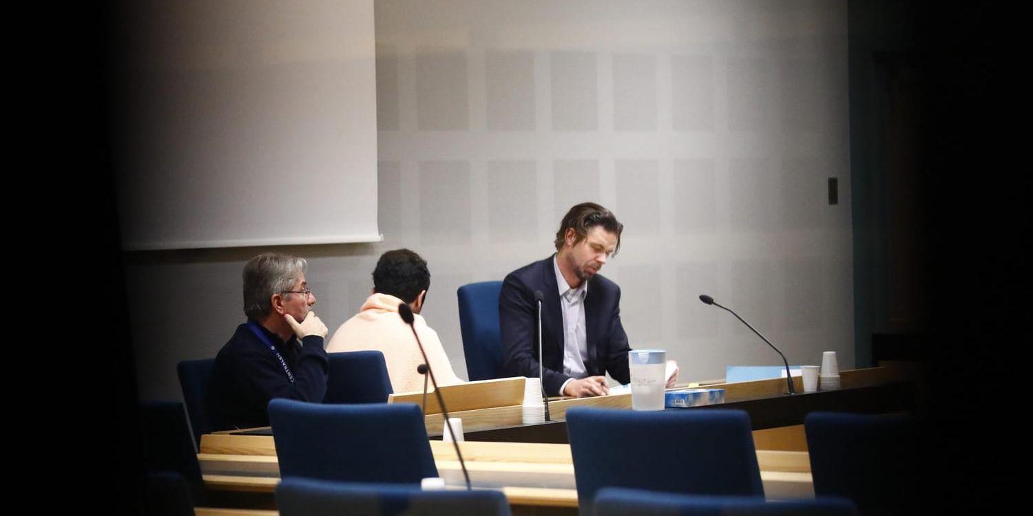 Två unga män har häktats för grov mordbrand efter attacken mot en synagoga i Göteborg. Här ses 18-åringen under häktningsförhandlingen, sittande mellan tingsrättens tolk och sin advokat Peter Olsson.