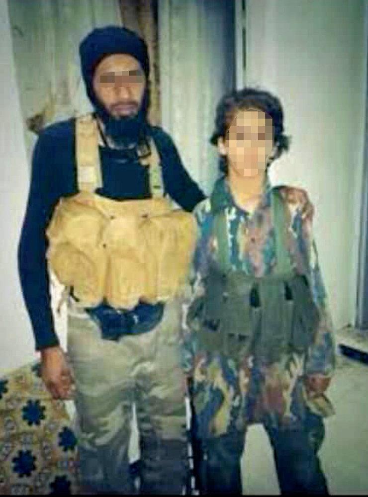 Ett av bildbevisen som åklagarna åberopar mot den 49-åriga kvinnan är det här fotot av hennes son som 13-åring jämte en vuxen IS-krigare.