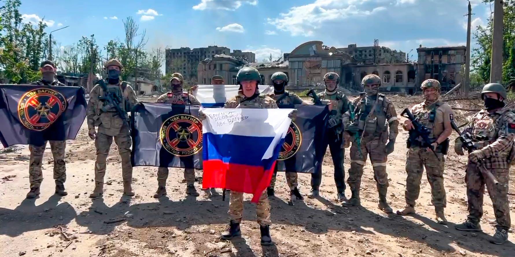 Jevgenij Prigozjin, som håller den ryska flaggan, poserar med soldater i Bachmut. Bilden distribuerades den 20 maj. Arkivbild.