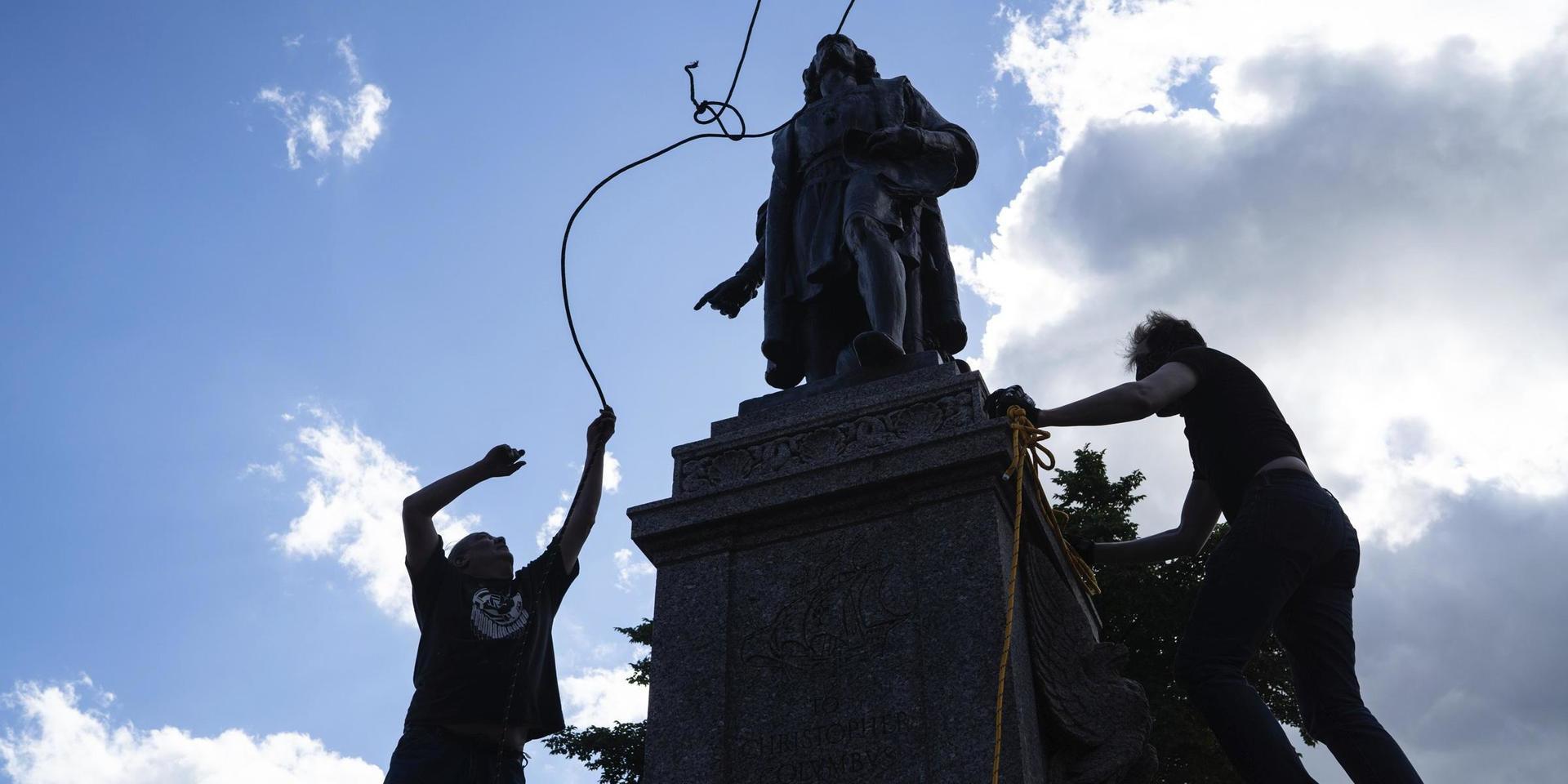 Demonstranter ger sig på en staty av Kristofer Columbus i Saint Pauls, Minnesota. Arkivbild.