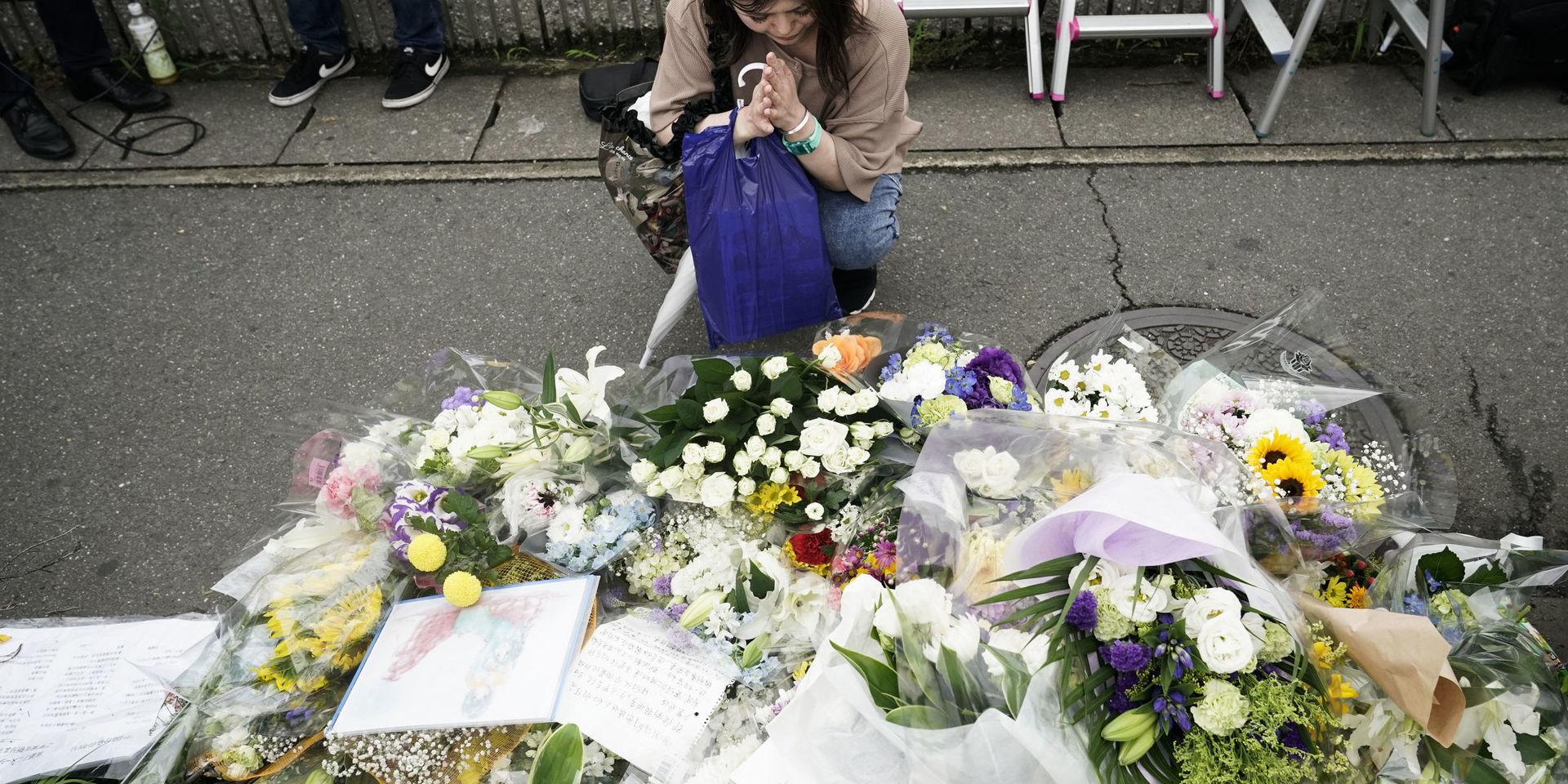 En kvinna ber för offren vid animationsstudion Kyoto Animation dagen efter den förödande branden.