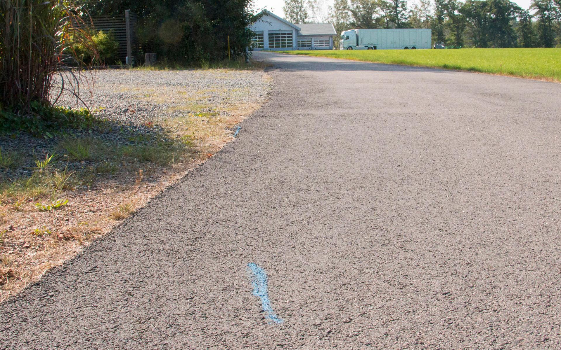 Asfalt har lagts i ett väghörn. Därmed ligger en del av asfalten i naturreservatet. Den blå markeringen visar gränsen.