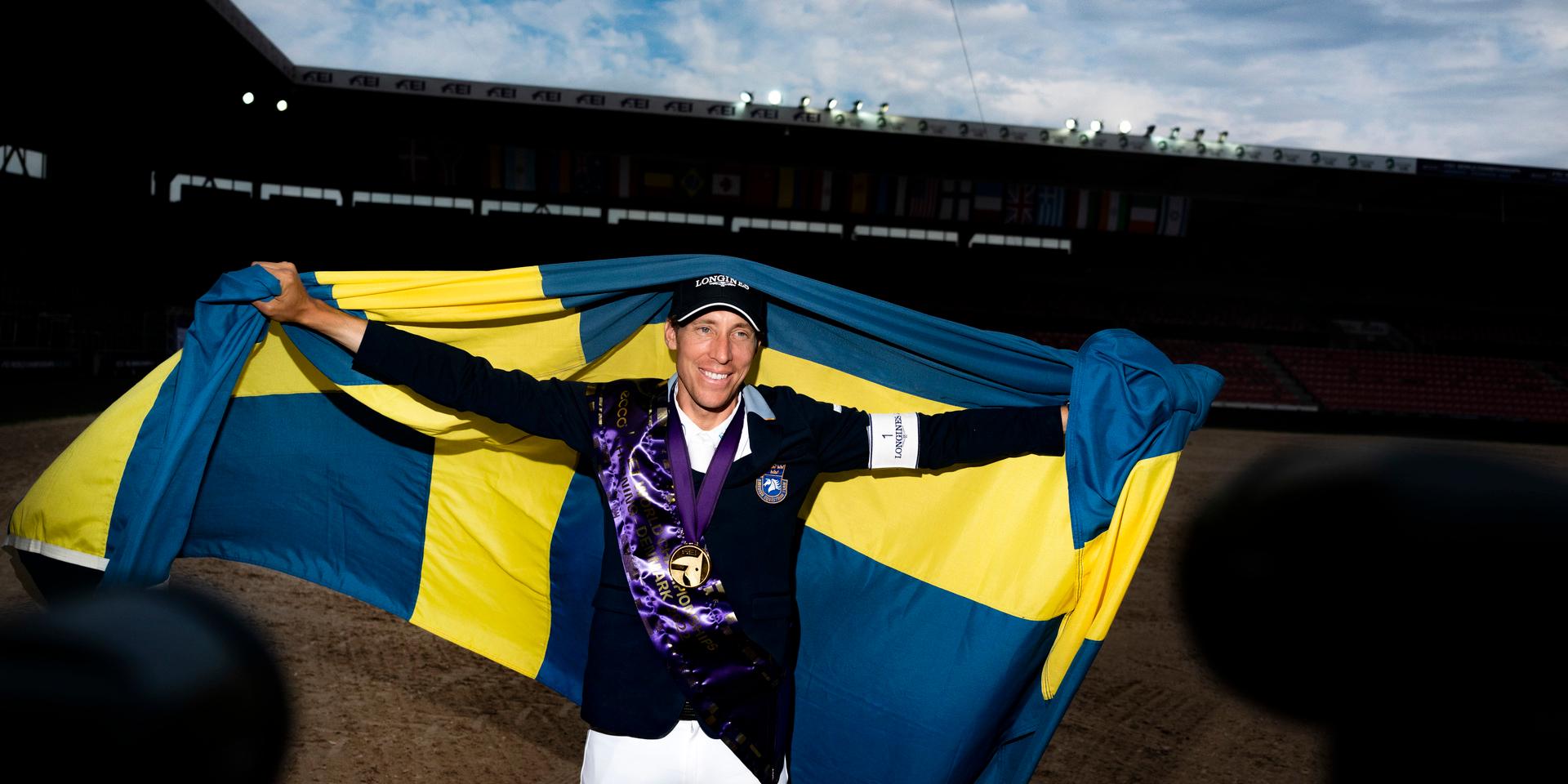 Henrik von Eckermann firar sitt individuella VM-guld med svenska flaggan.