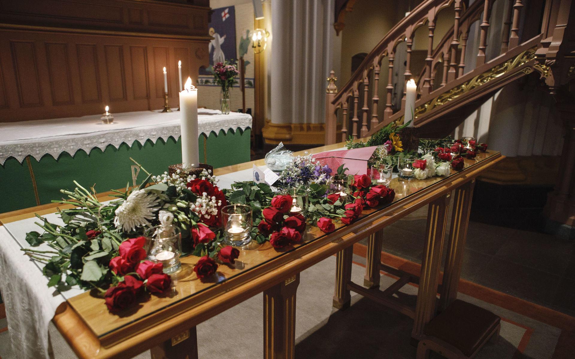 Tända ljus och blommor under minnesceremonin i Umeå stads kyrka för de nio personer från Umeå fallskärmsklubb som omkom i flygkraschen.