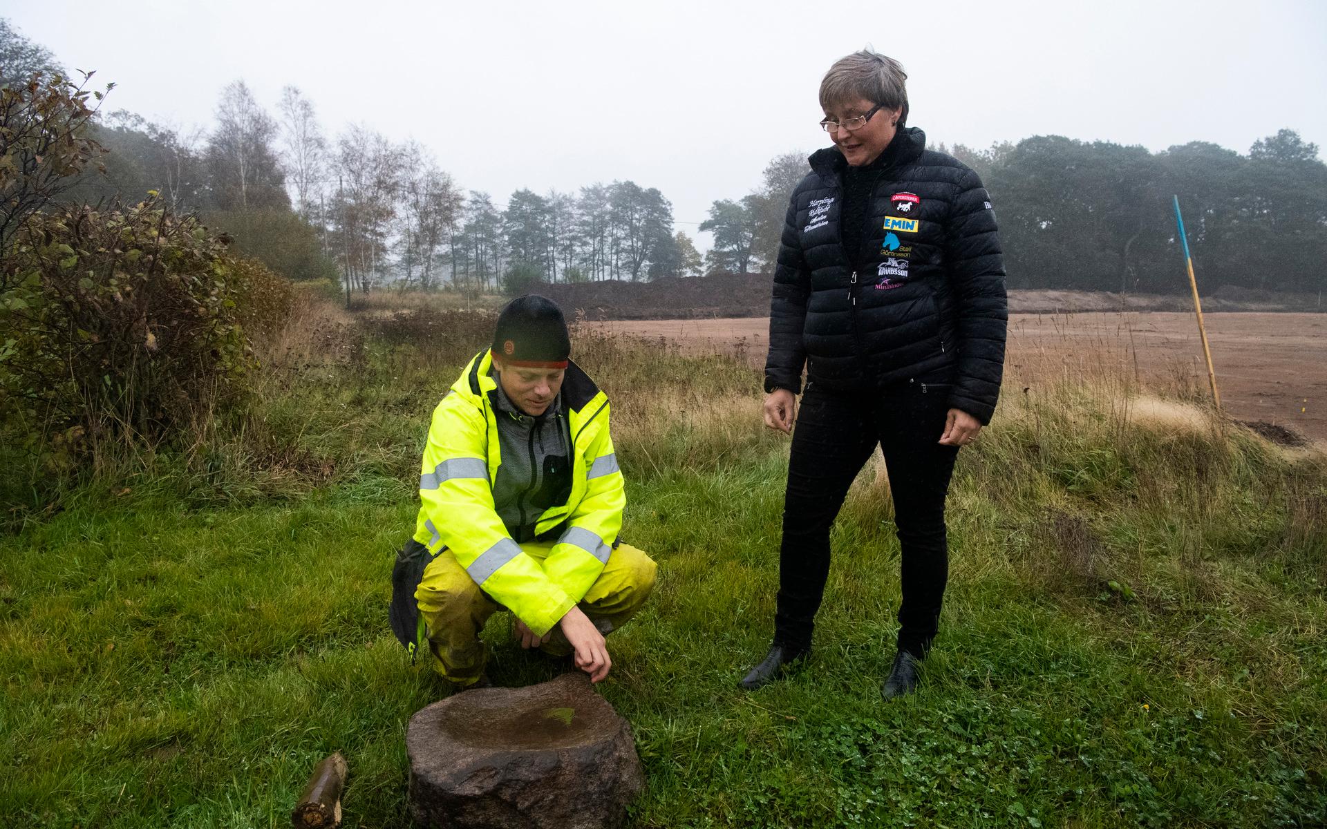 Johan Klange visar den malstensunderliggare, det vill säga en del av en tidig kvarn, som har hittats på platsen.