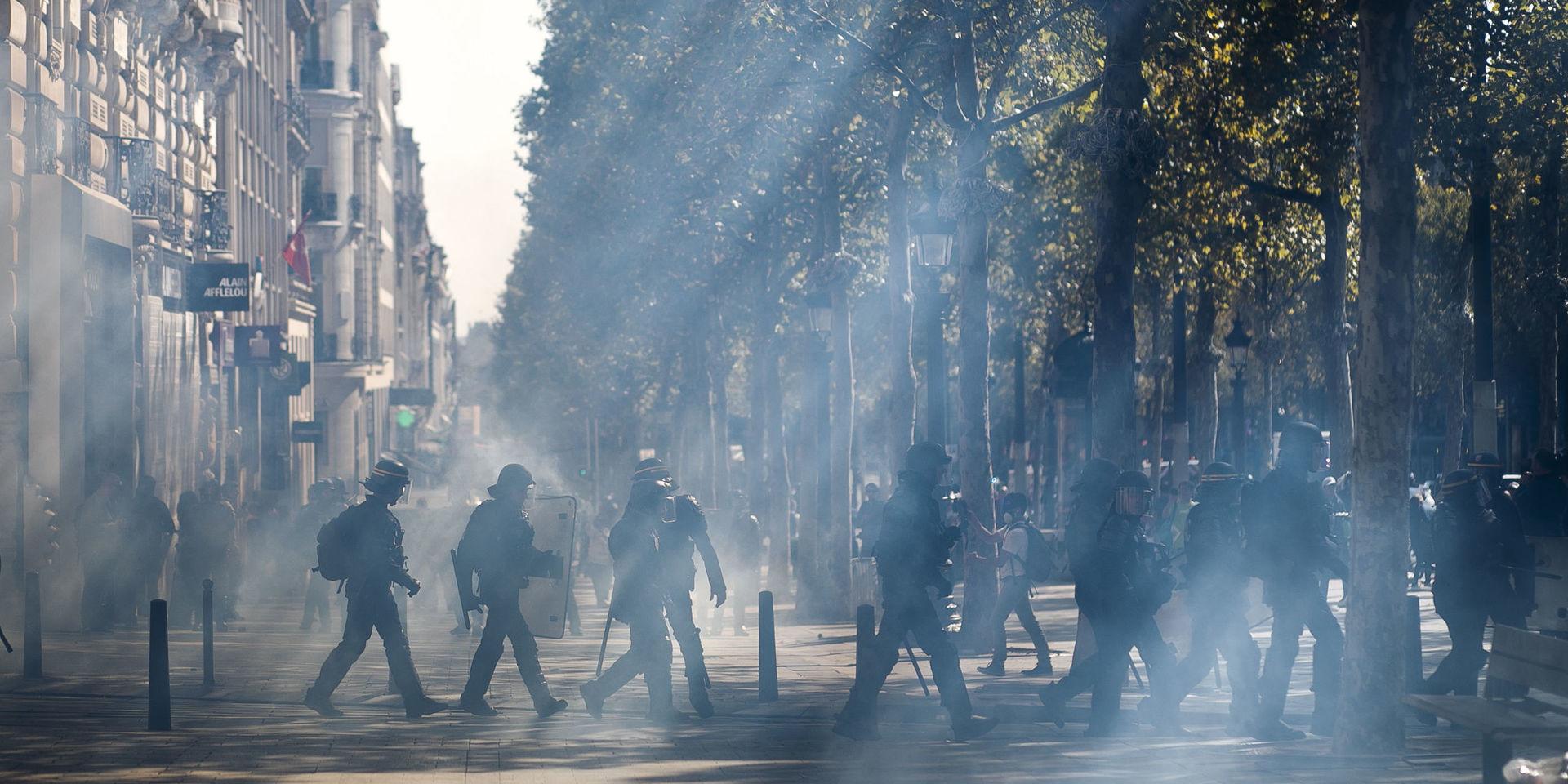 Kravallpolis på Champs-Élysées efter att tårgas använts mot demonstranter i Paris. 