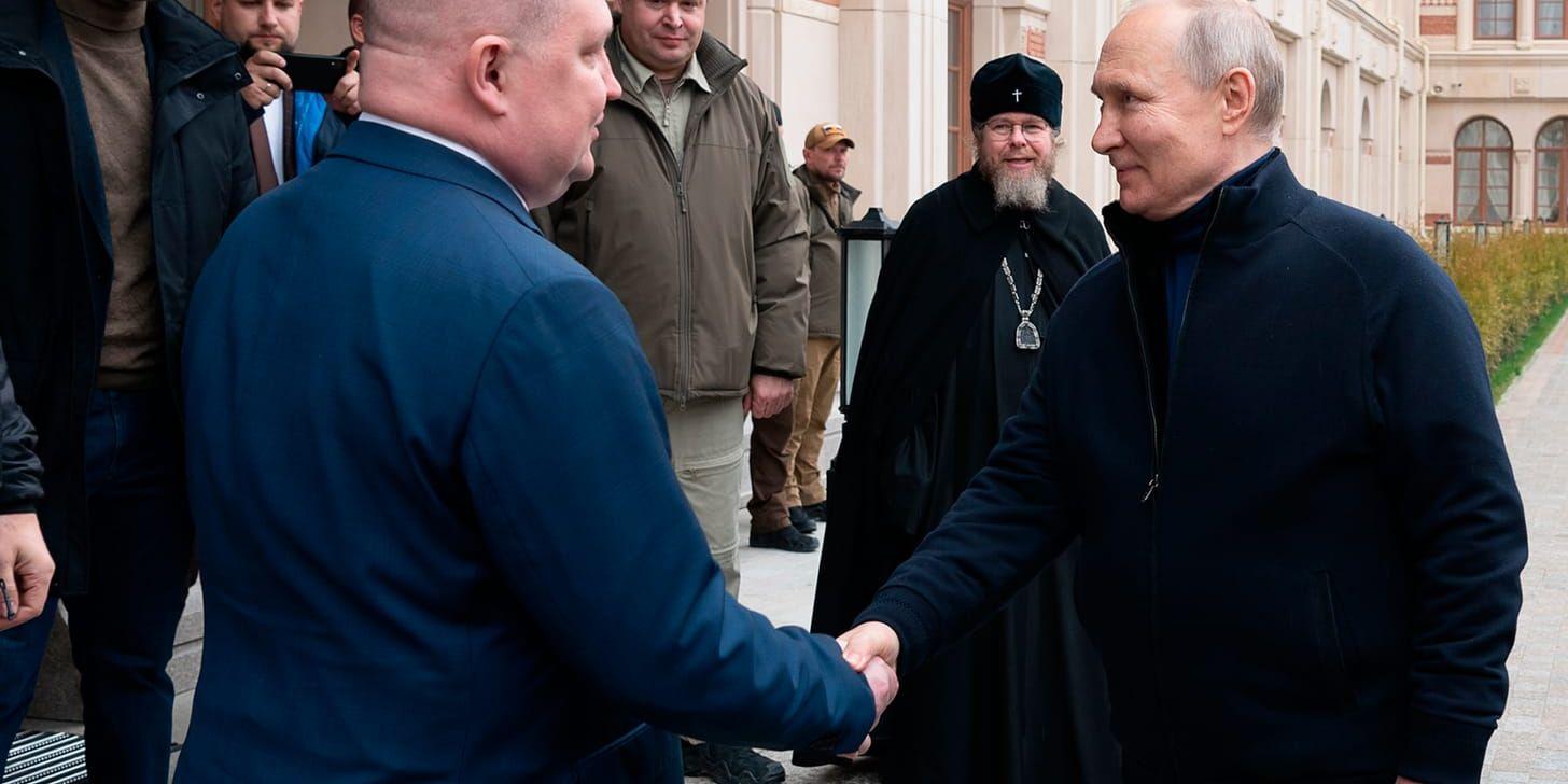 Rysslands president Vladimir Putin hälsar på den av Ryssland tillsatte guvernören Michail Razvozjajev.