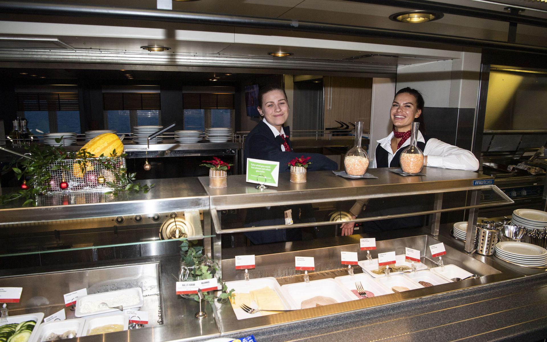 Den som väljer morgonfärjan från Halmstad kan inleda med en rejäl frukostbuffé i båtens restaurang. Restaurangbiträdena Klara Carlsson och Saara Köhli, båda boende i Halmstad, hälsar välkomna.