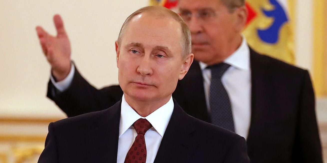 Rysslands president Vladimir Putin med utrikesminister Sergej Lavrov i bakgrunden.