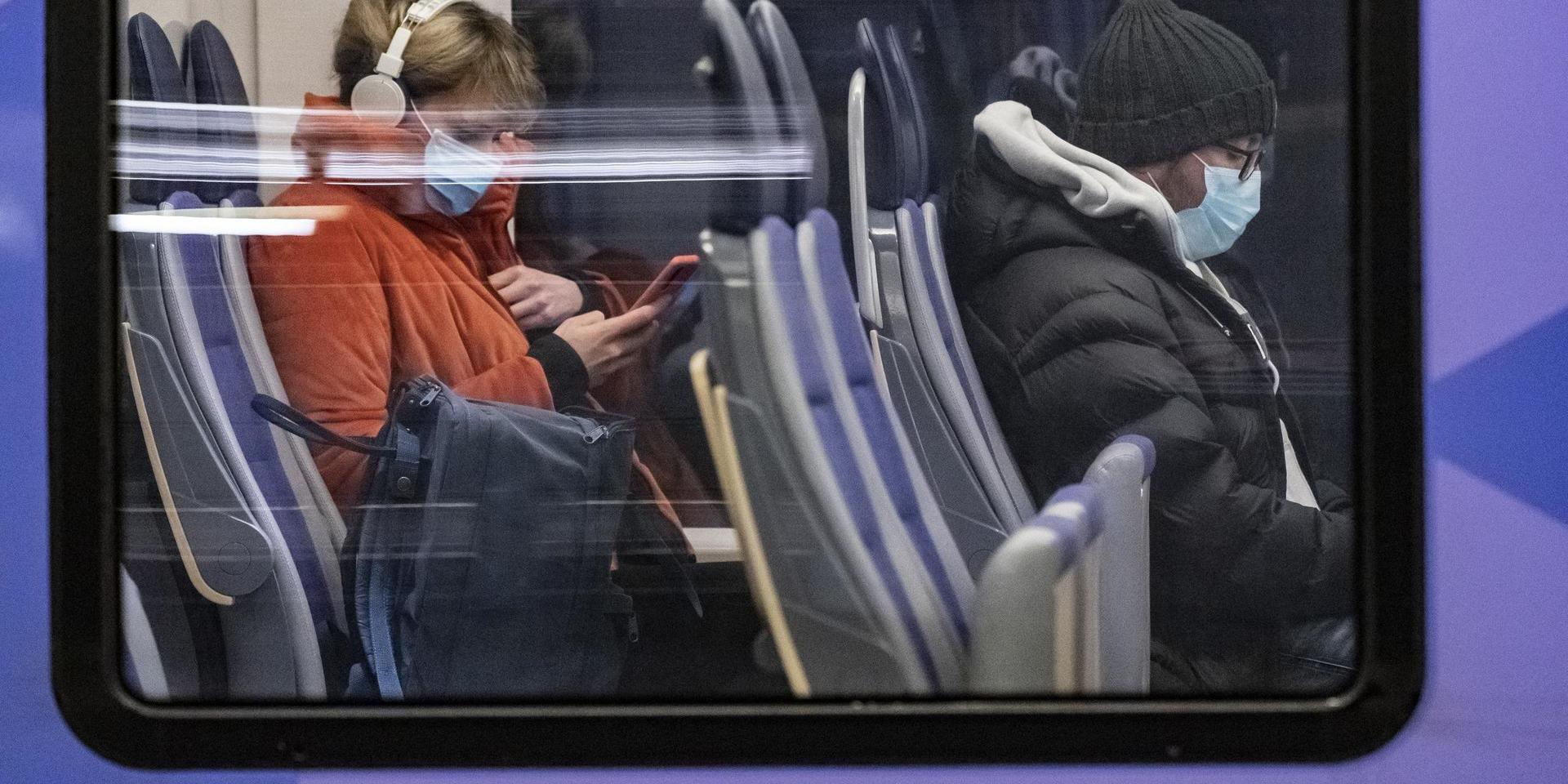 Resenärer med munskydd på ett Pågatåg på Malmö C i kvällsrusningen.