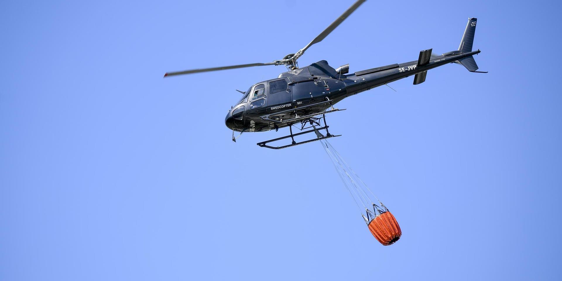 En helikopter hjälper till i samband med branden.