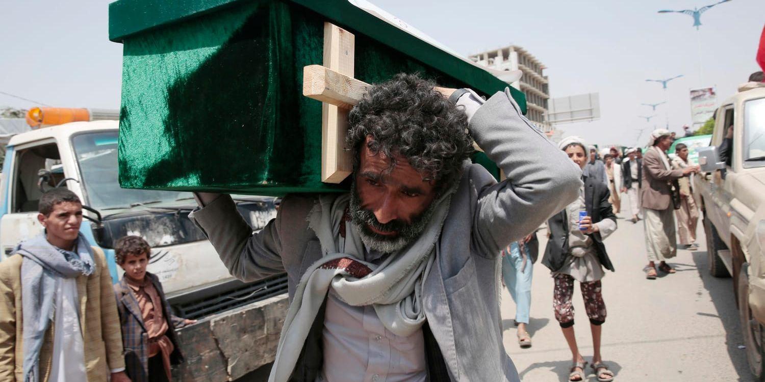 En jemenitisk man bär en kista med ett av offren för en flygattack mot norra Jemen, utförd av den saudiskledda alliansen. Tiotals människor dödades i attacken, som fick FN att kräva en utredning. Bilden är från 13 augusti i år.