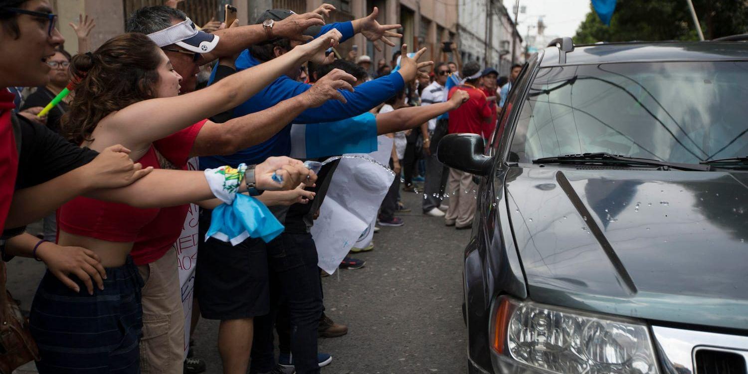 Demonstranter skanderar slagord mot kongressledamöter som anländer till kongressen i Guatemala City på fredagen.