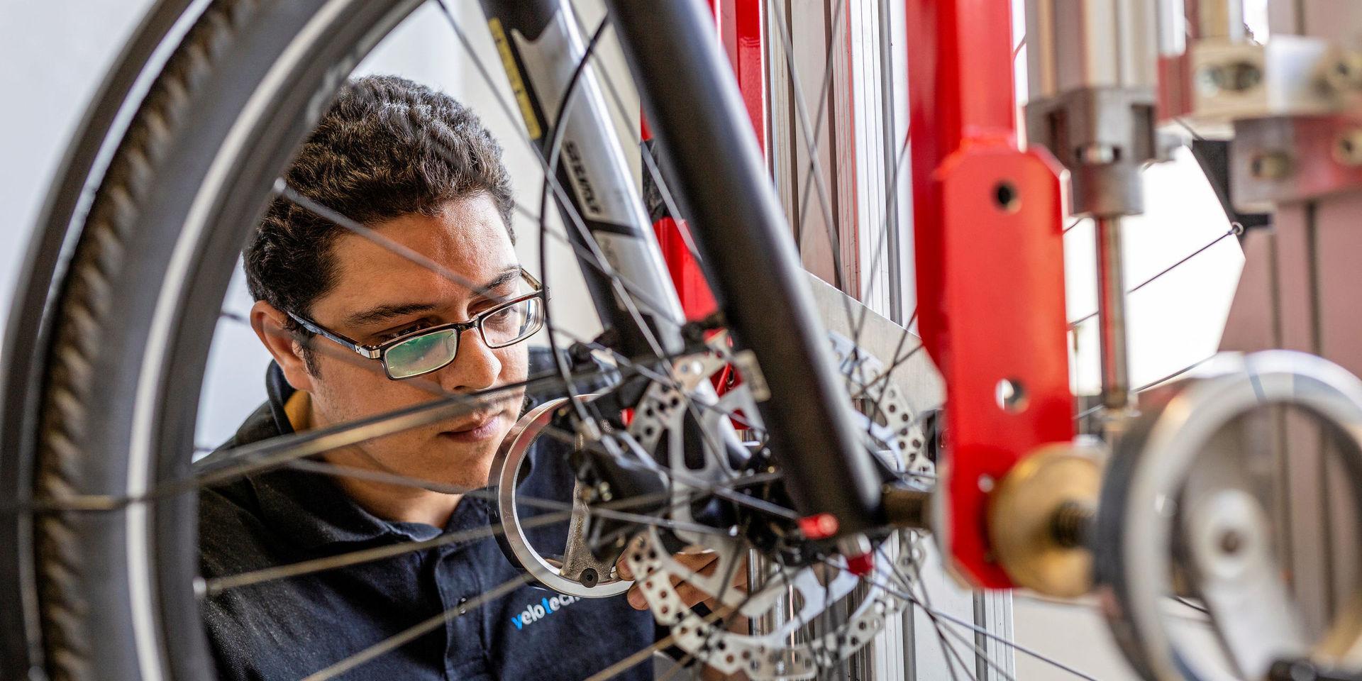 Redouane Bouassaba, testtekniker på velotech.de, fixerar cykelns hjul i testriggen eRig.