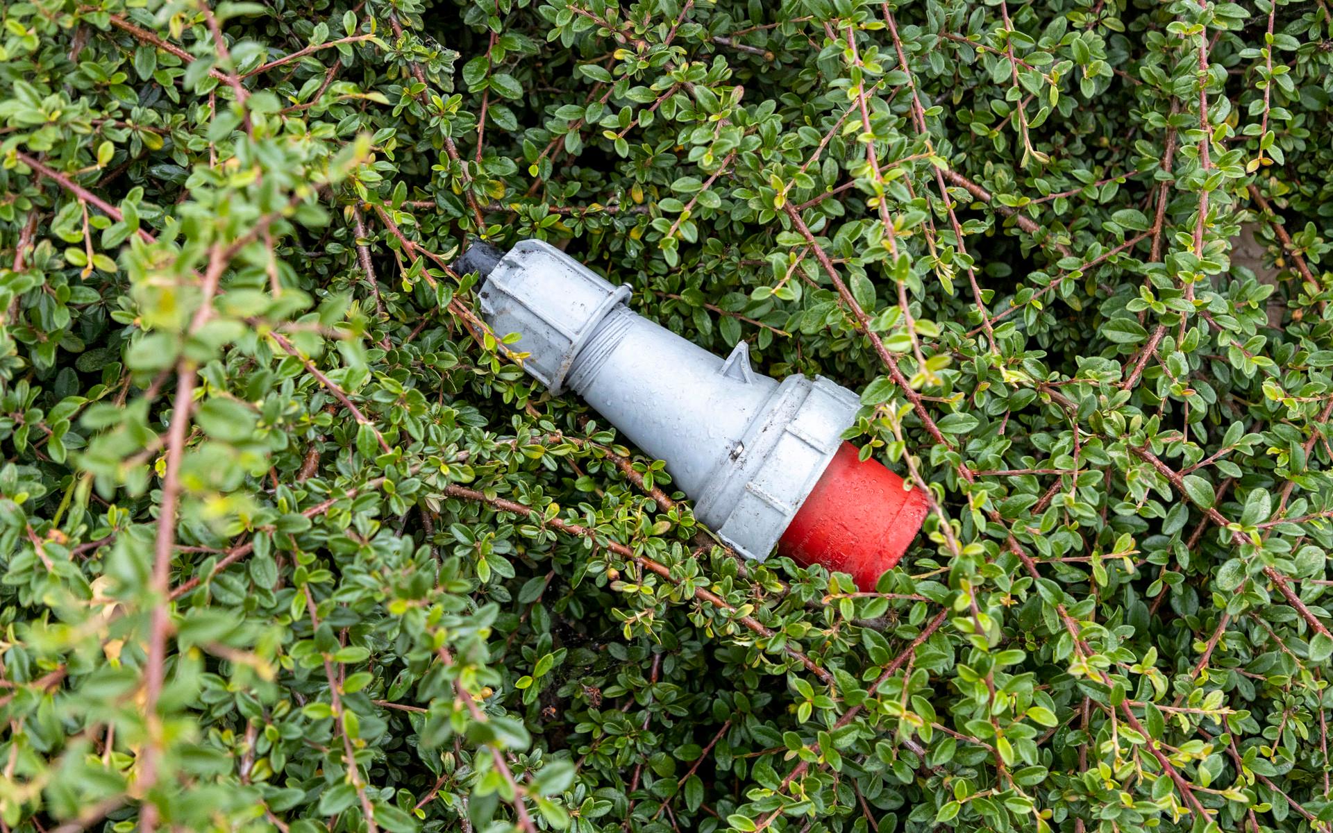 En kabelhandske ligger slängd i en buske. 