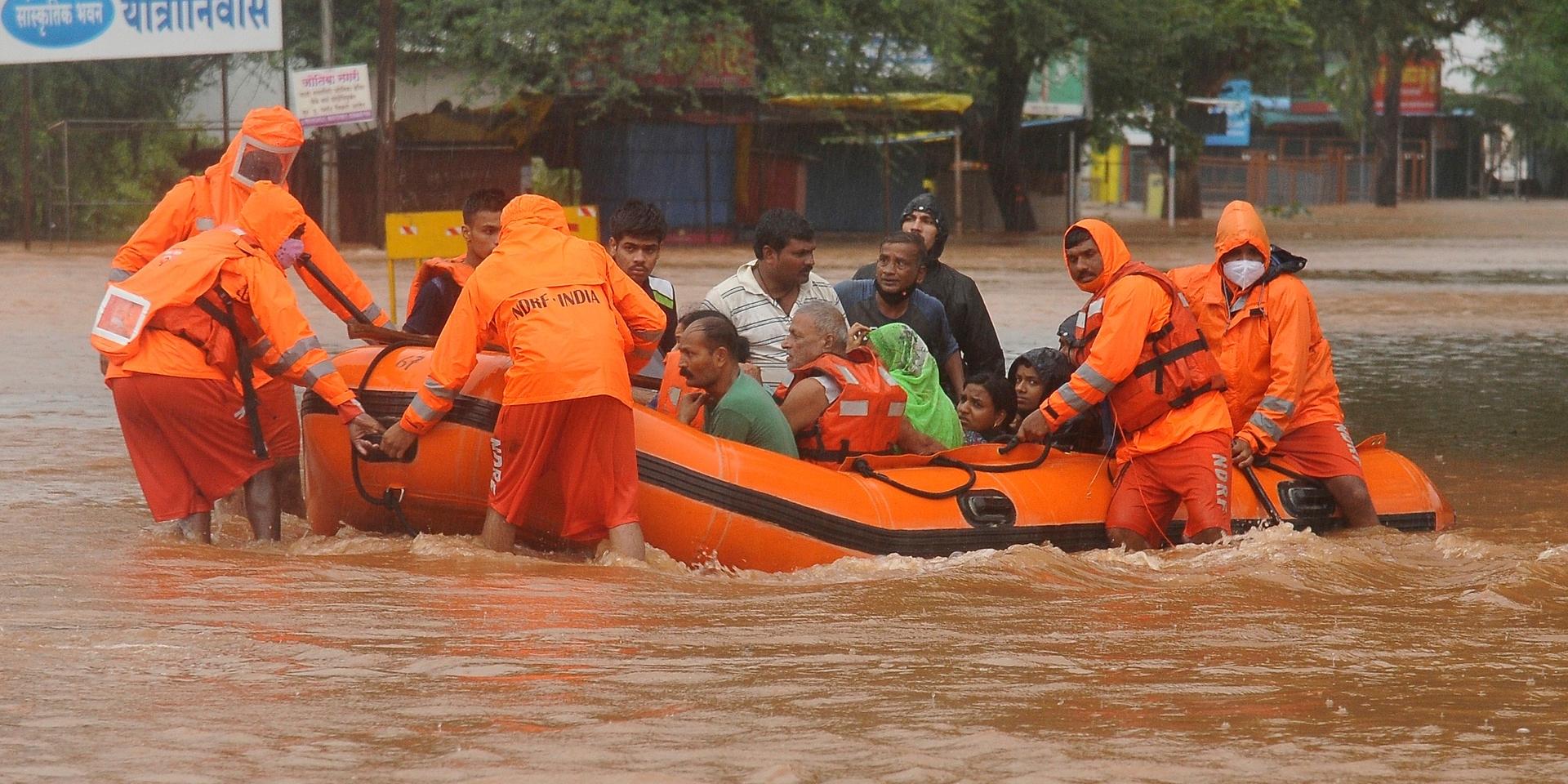 Räddningspersonal evakuerar människor som strandsatts i översvämningar i Kolhapur i västra Indien, efter kraftiga monsunregn.