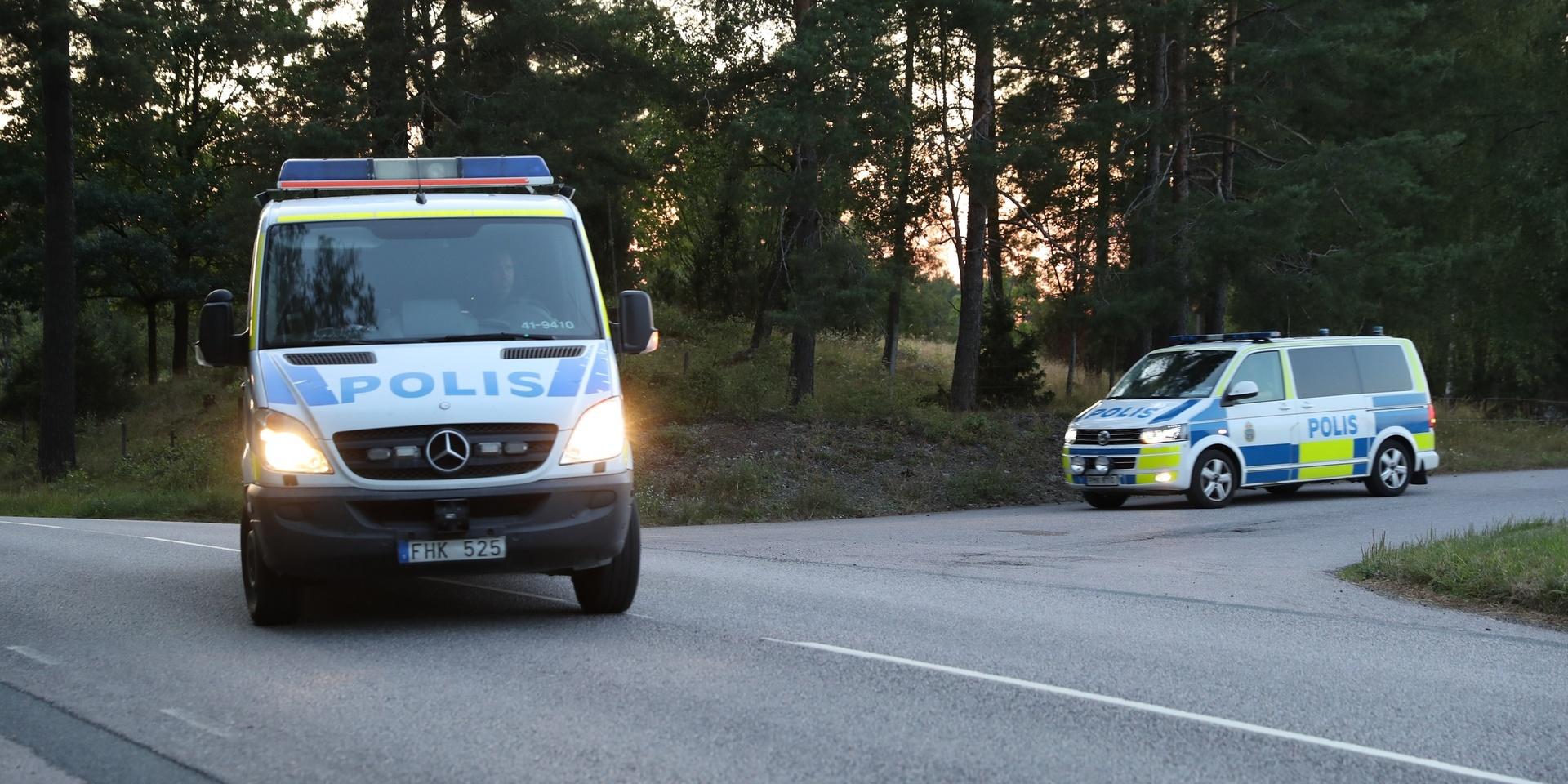 Två polispiketer lämnar fängelseområdet i Hällby i samband med att faran avblåsts.